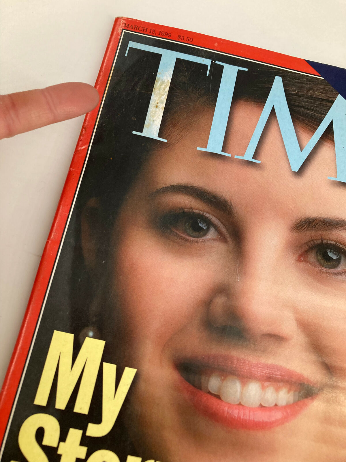 Detail of the Time Magazine cover from March 15, 1999, showing the title 'My Story' and a close-up of Monica Lewinsky's face, with visible wear on the magazine.
