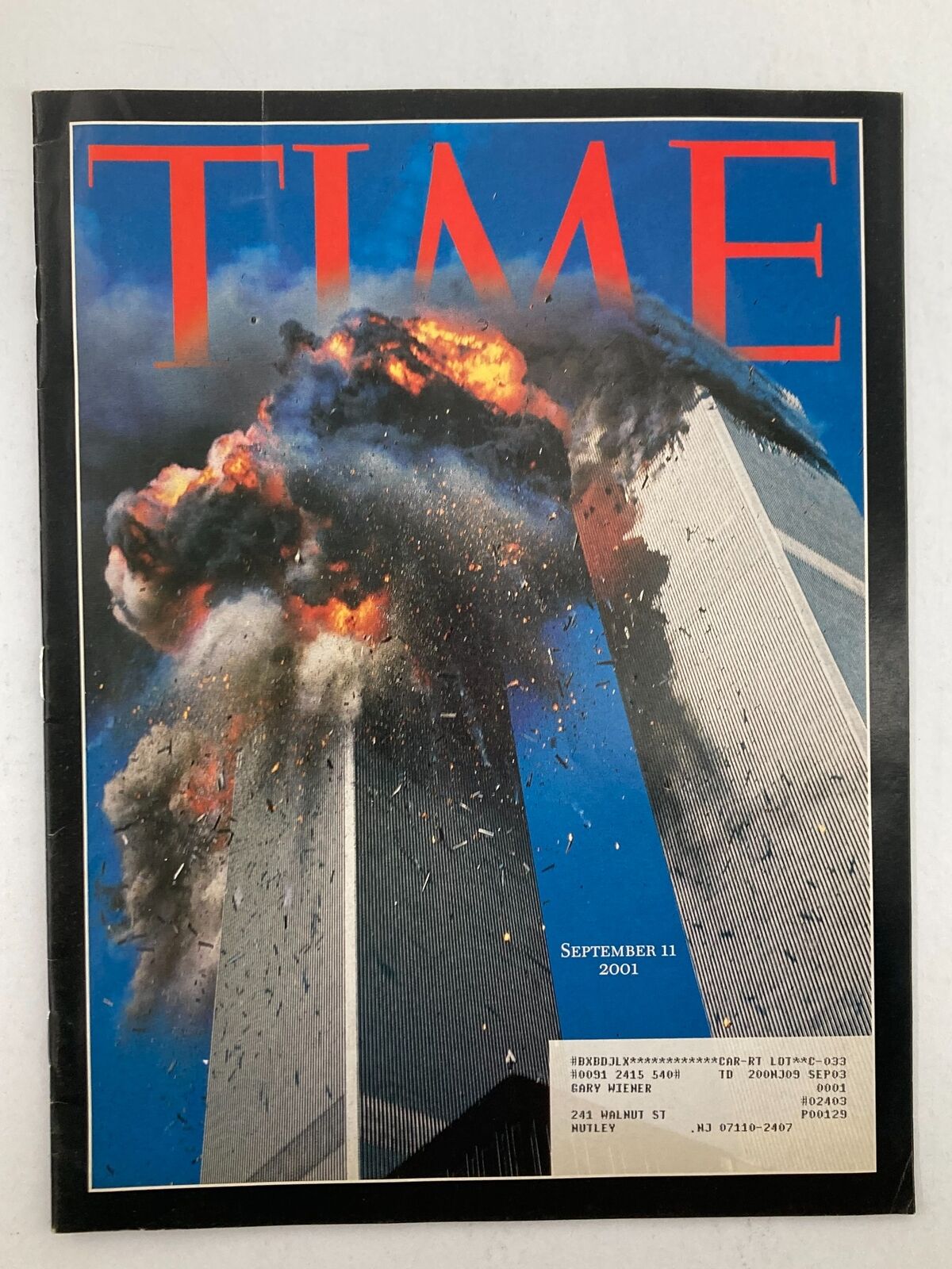 Time Magazine cover from September 11, 2001, depicting the Twin Tower attack with flames and debris, highlighting the tragic events of 9-11.