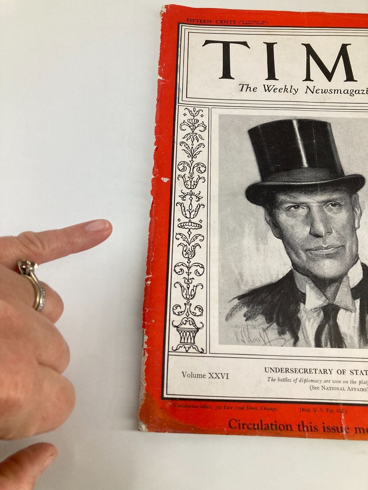 Detailed view of the cover of VTG Time Magazine December 9, 1935, Vol 26 No. 24, with a hand pointing at the side of the magazine.