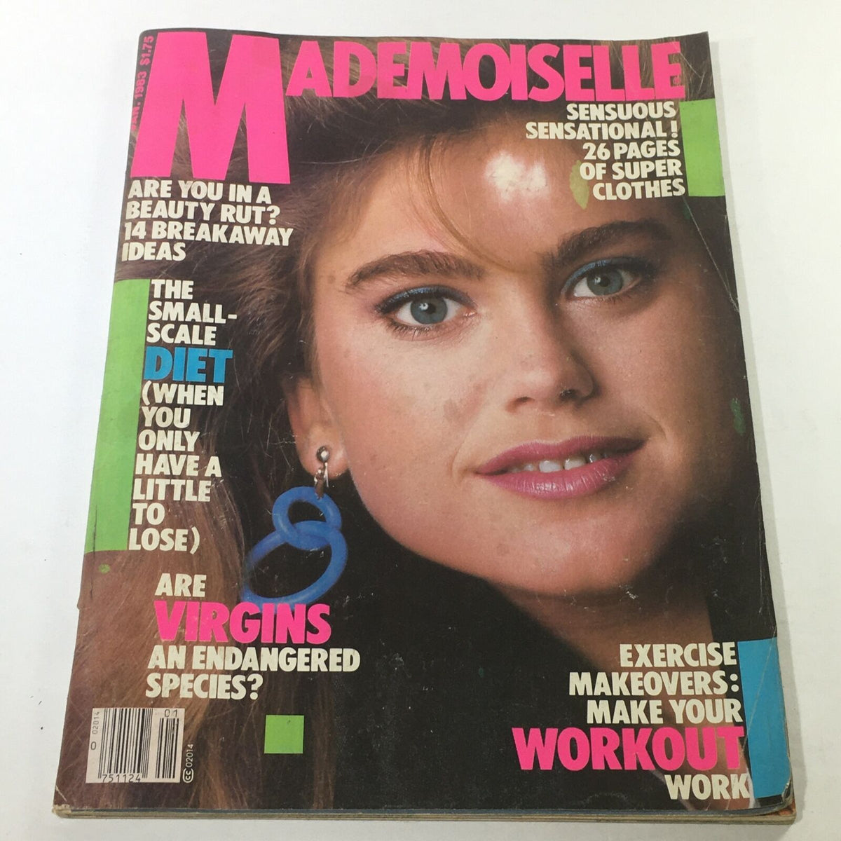 Cover of VTG Mademoiselle Magazine: January 1983, featuring a close-up of a model with blue earrings and vibrant makeup. The cover highlights articles related to beauty, diet, and fashion trends from the early 1980s.