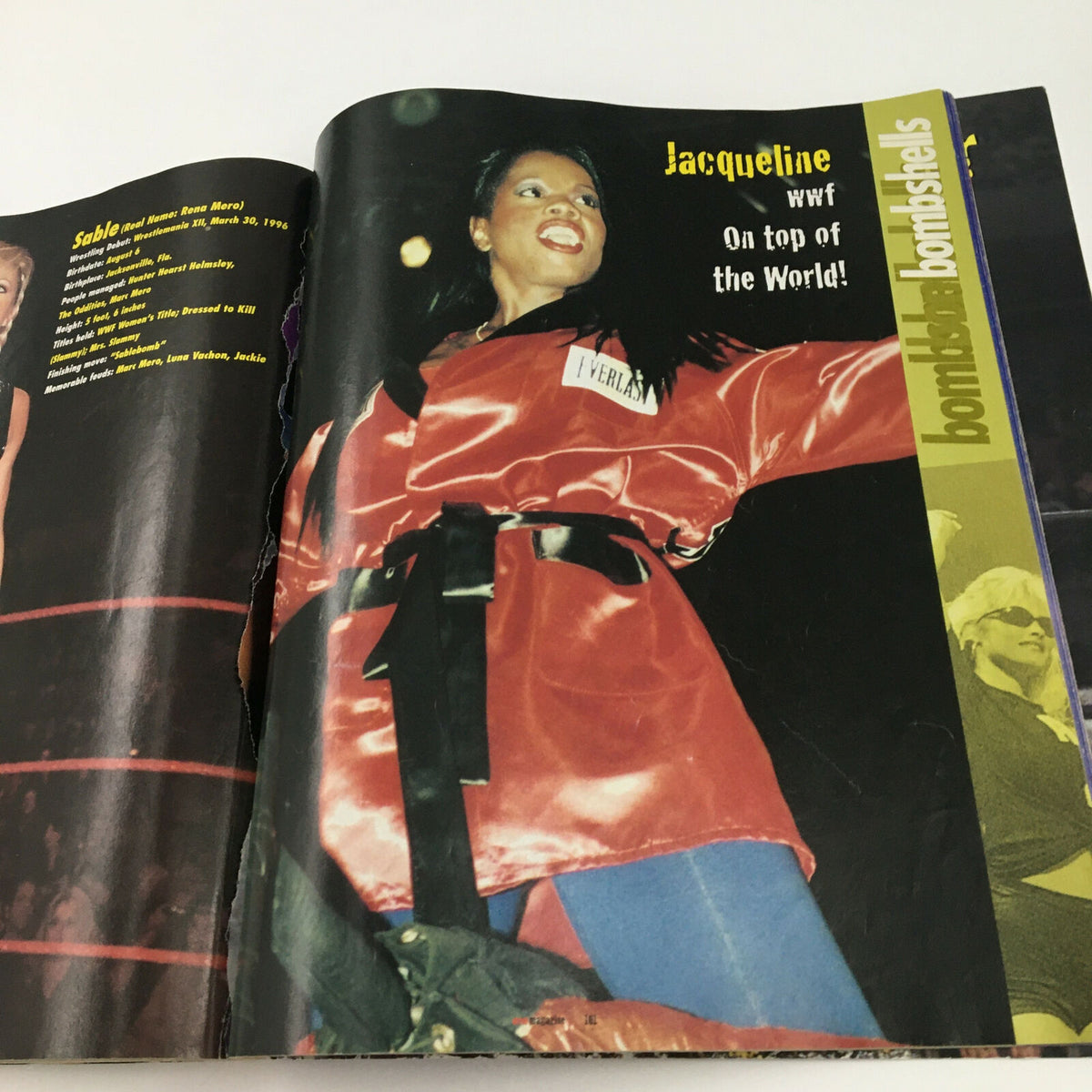 WWF World of Wrestling Magazine May 1999 showcasing Jacqueline in a striking red outfit, exuding confidence with the caption 'On top of the World!'. Ideal for vintage wrestling fans.