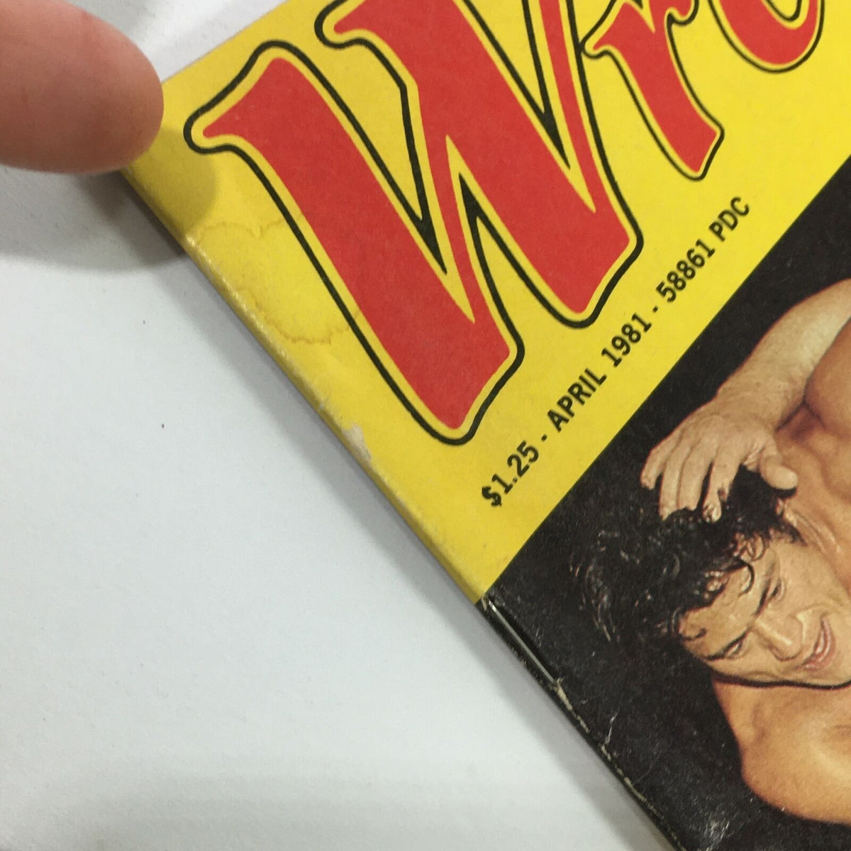 Close-up of the corner of VTG The Ring's Wrestling Magazine April 1981, showing wear and tear typical for vintage magazines, with the title prominently displayed.
