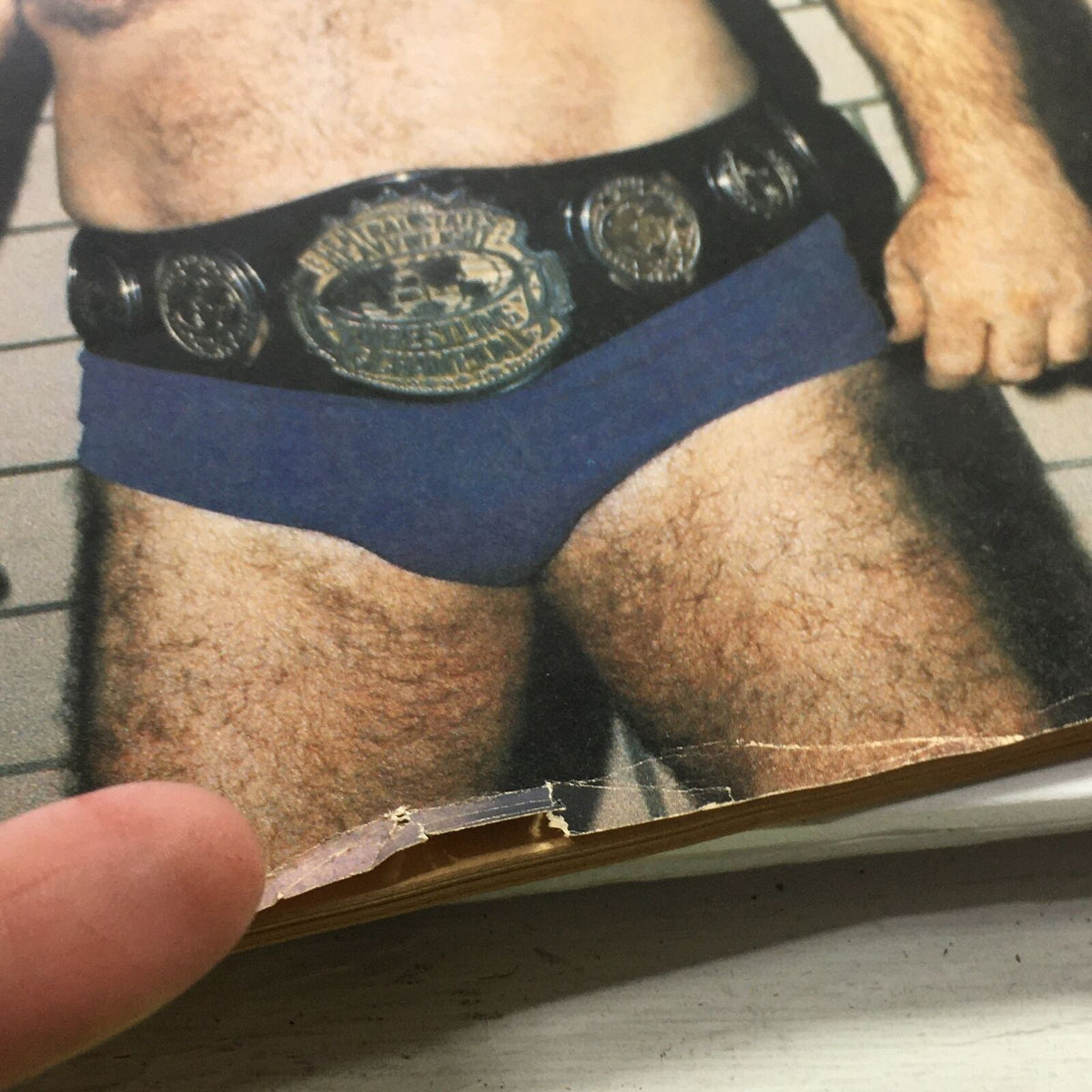 Detailed view of a featured wrestler in VTG The Ring's Wrestling Magazine April 1981, showcasing championship belts and the classic wrestling attire.