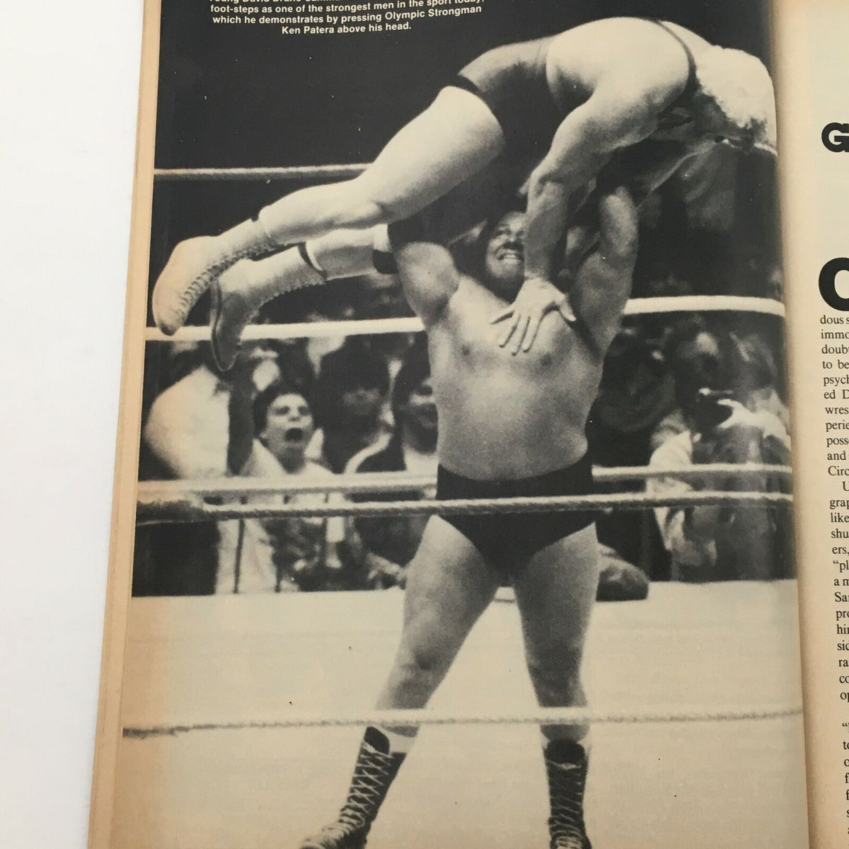Action shot from Wrestling's Main Event Magazine May 1985 depicting a wrestling match with a wrestler performing a strongman lift in the ring.