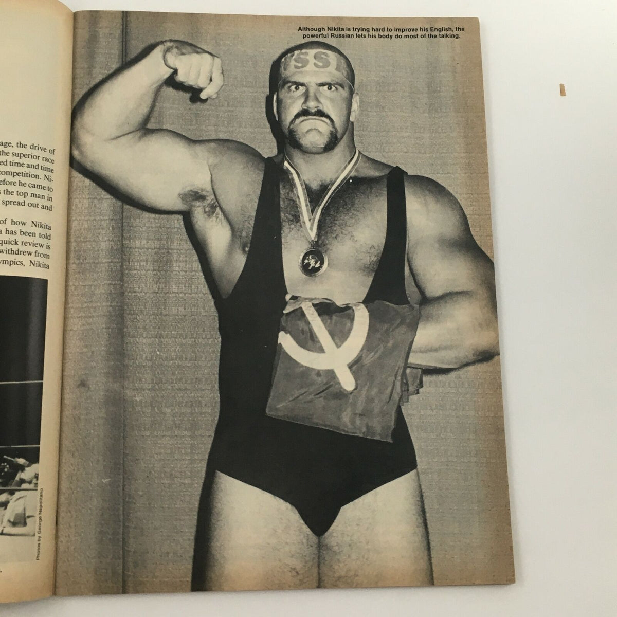 Wrestling's Main Event Magazine May 1985 featuring Nikita Koloff, showcasing the powerful wrestler posing with a medal and a Soviet flag, highlighting the era's wrestling culture.