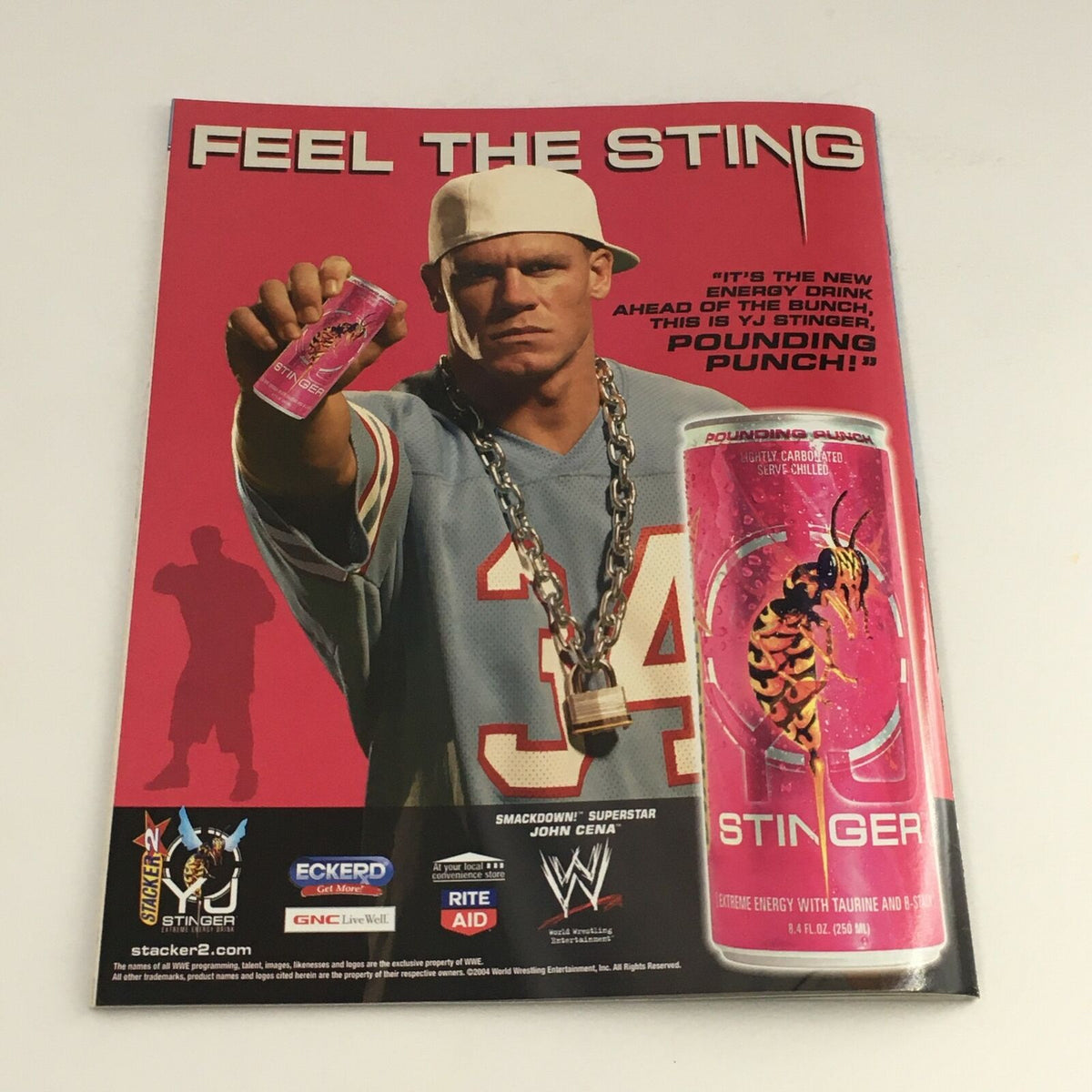 WWE Smack Down Magazine November 2004 ad featuring John Cena promoting Stinger energy drink. Captivating image showcasing Cena's persona and branding within WWE merchandise.