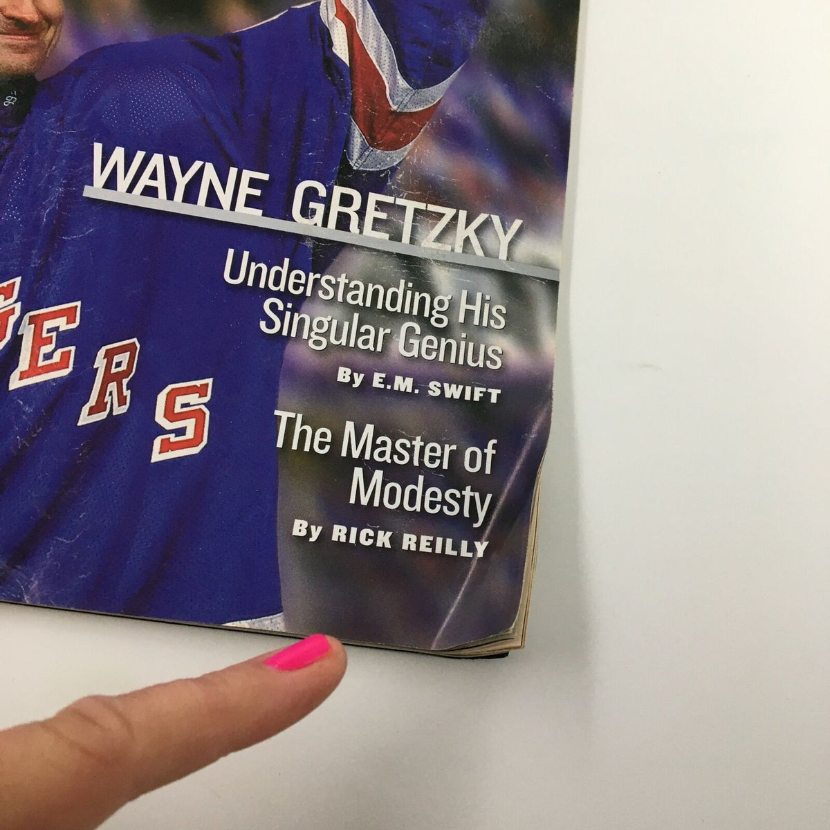 Close-up of Sports Illustrated magazine cover featuring Wayne Gretzky titled 'A Singular Genius,' with articles 'Understanding His Singular Genius' by E.M. Swift and 'The Master of Modesty' by Rick Reilly.
