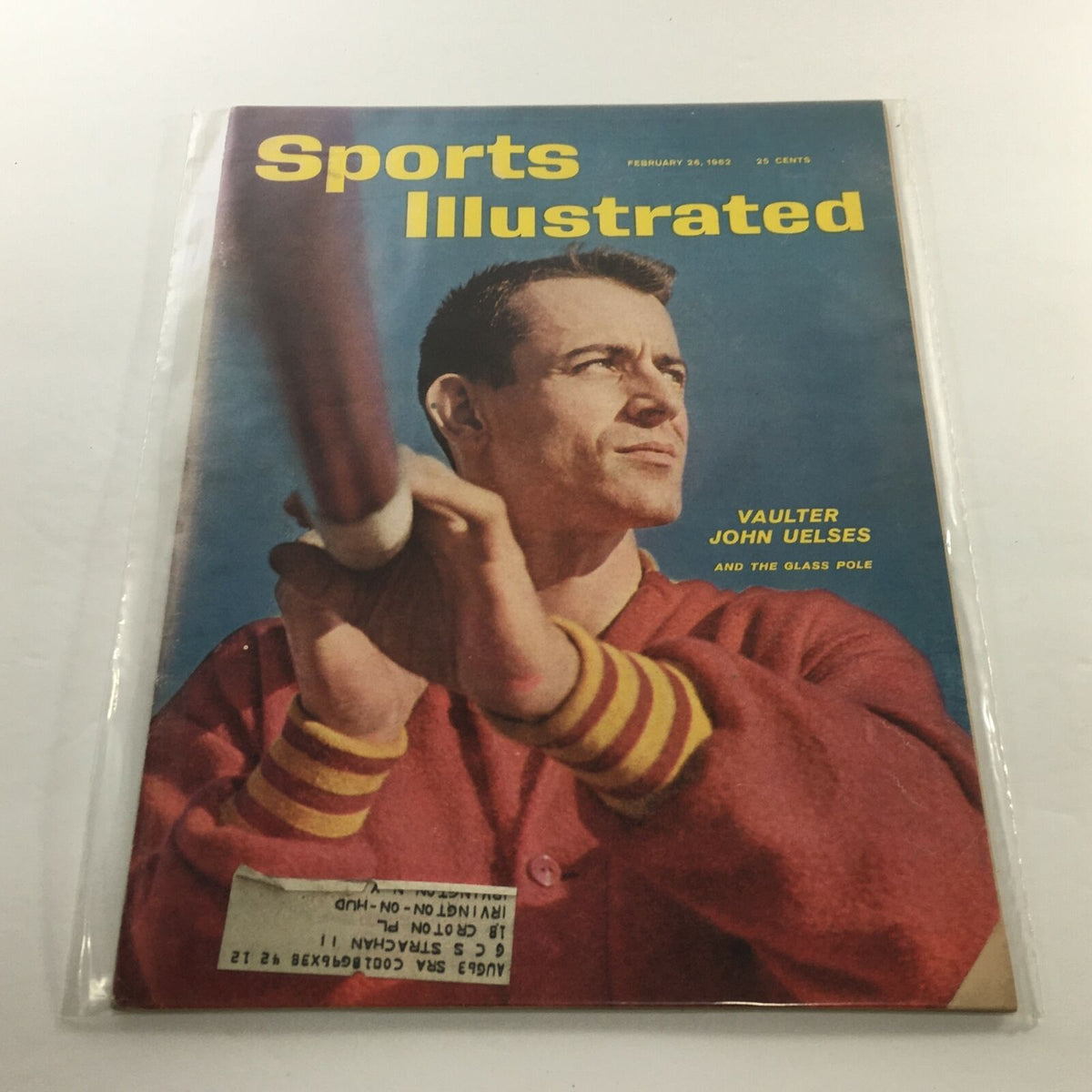 Sports Illustrated cover from February 26, 1962, featuring vaulter John Uelses holding a glass pole, with an address label on the front and plastic protective covering, showcasing minor edge wear.