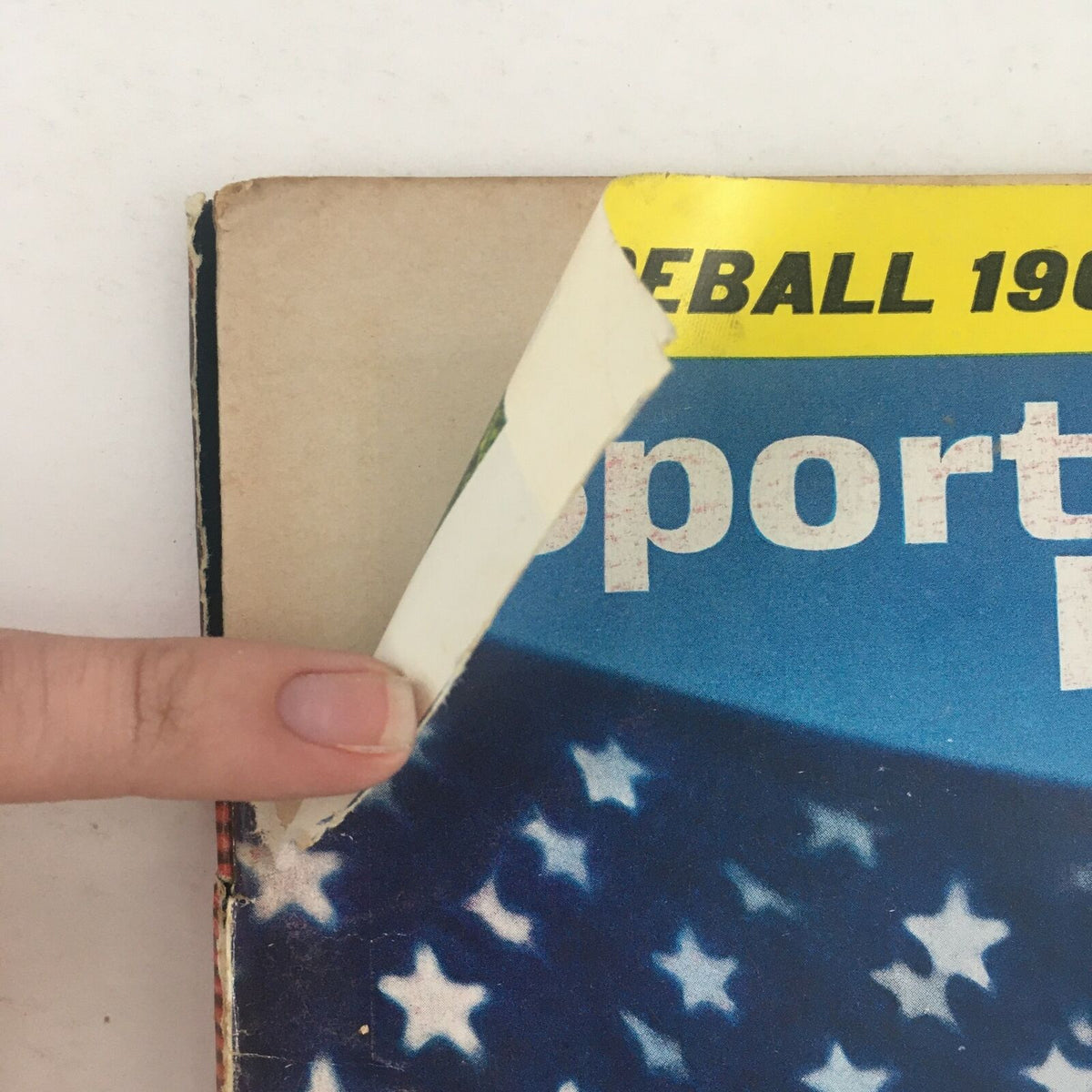 Detail showing the edge of Sports Illustrated Magazine, April 19, 1965, with minor wear and a partially detached cover illustrating its vintage condition.