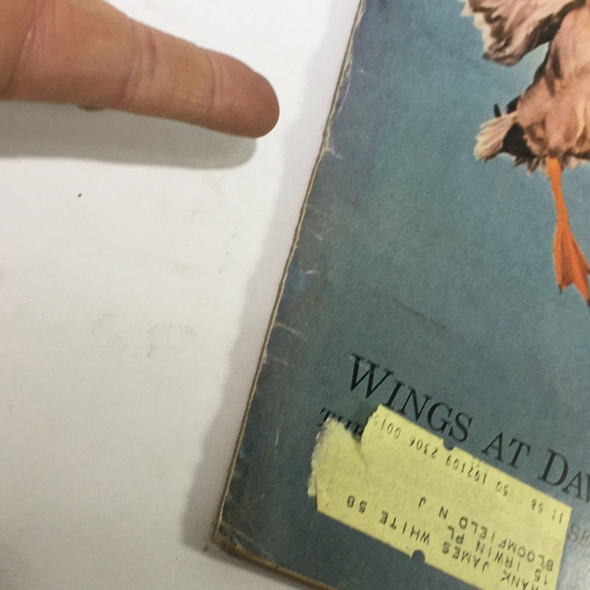 Close-up view of the edge of the VTG Sports Illustrated Magazine from October 21, 1957 titled 'Wings at Dawn,' highlighting the cover's condition and an affixed address label.