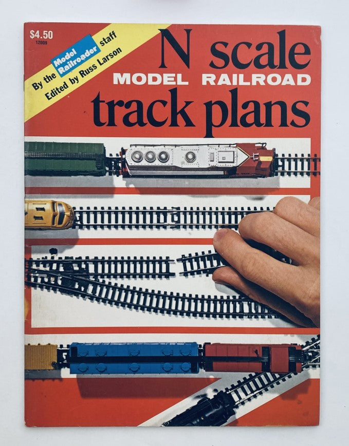 Cover of the N Scale Model Railroad Track Plans Book by Russ Larson, featuring vibrant colors and a hand interacting with model trains on a track.