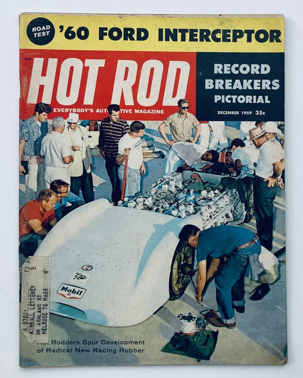Cover of VTG Hot Rod Magazine December 1959, Vol 12 No. 12 featuring 'Radical New Racing Rubber' with an image of car enthusiasts gathered around a racing vehicle.