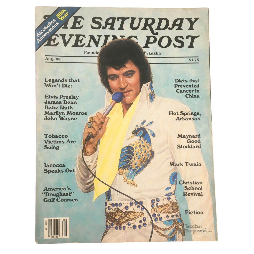 The Saturday Evening Post August 1985 featuring Elvis Presley on the cover, showcasing the King of Rock and Roll with a microphone, wearing a vibrant white suit adorned with blue details.