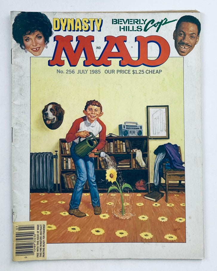 Cover of Mad Magazine July 1985 No. 256 featuring humorous illustrations related to Dynasty and Beverly Hills Cop, showcasing a boy watering a sunflower. The magazine is priced at $1.25.