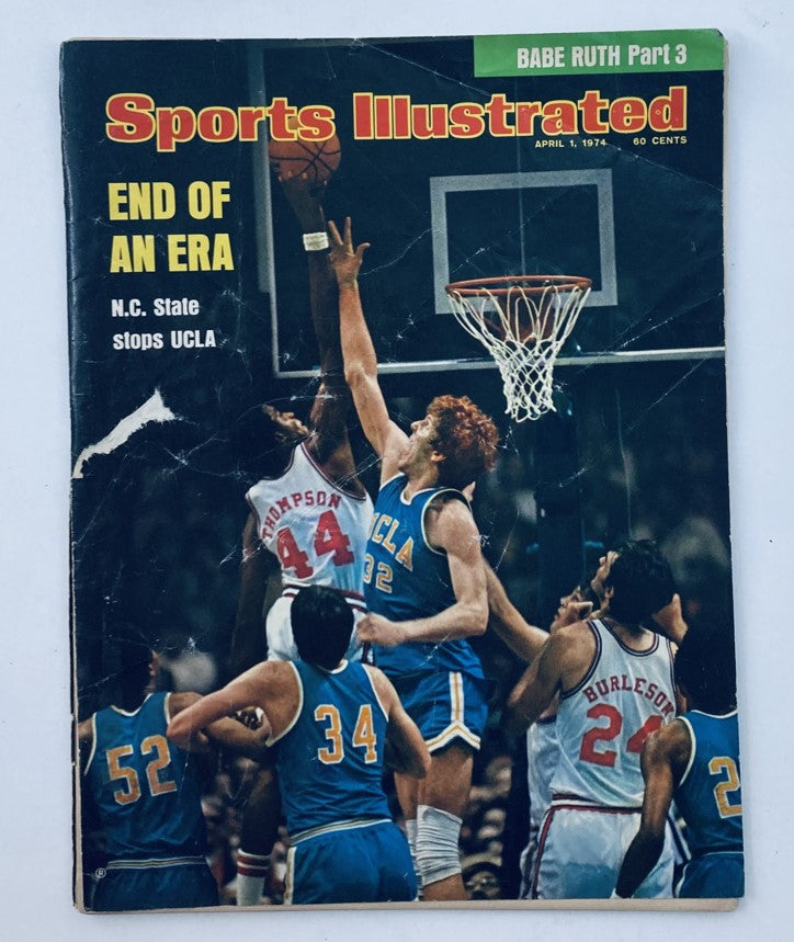 Sports Illustrated Magazine cover from April 1, 1974, featuring NC State's historic victory over UCLA, captioned 'END OF AN ERA', showcasing basketball action during this landmark game.