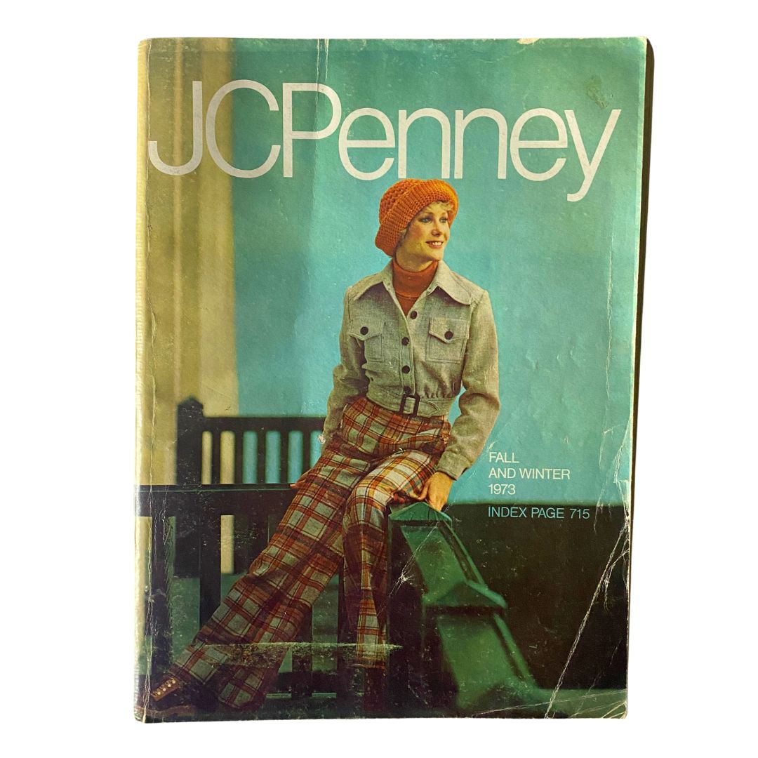 1973 JCPenney Fall and Winter All in Layers Catalog cover featuring a model in a stylish plaid outfit and orange knit hat, showcasing retro fashion trends.