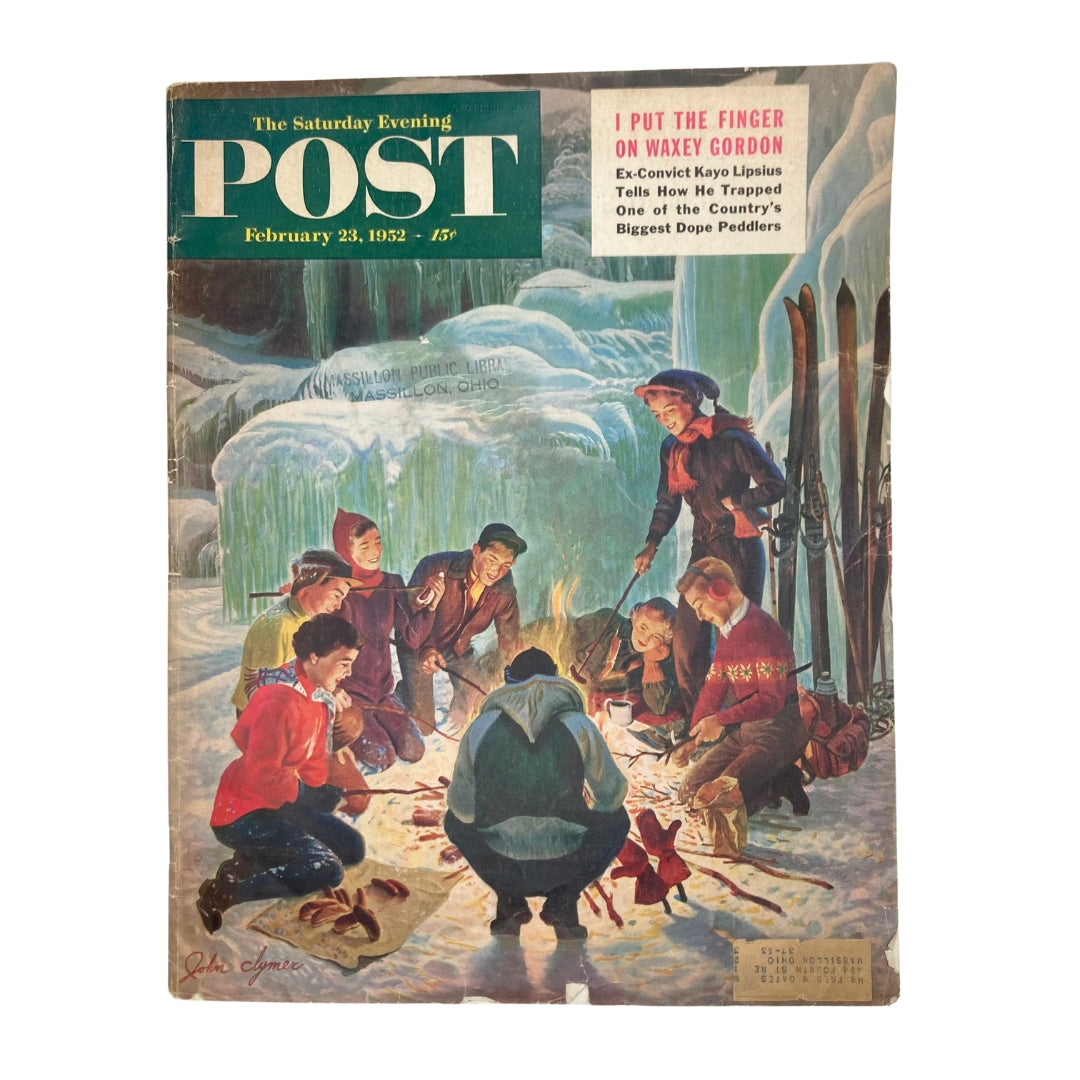 Saturday Evening Post Magazine Cover - February 23, 1952, featuring a nostalgic winter scene with children gathered around a campfire, artwork by John Clymer.