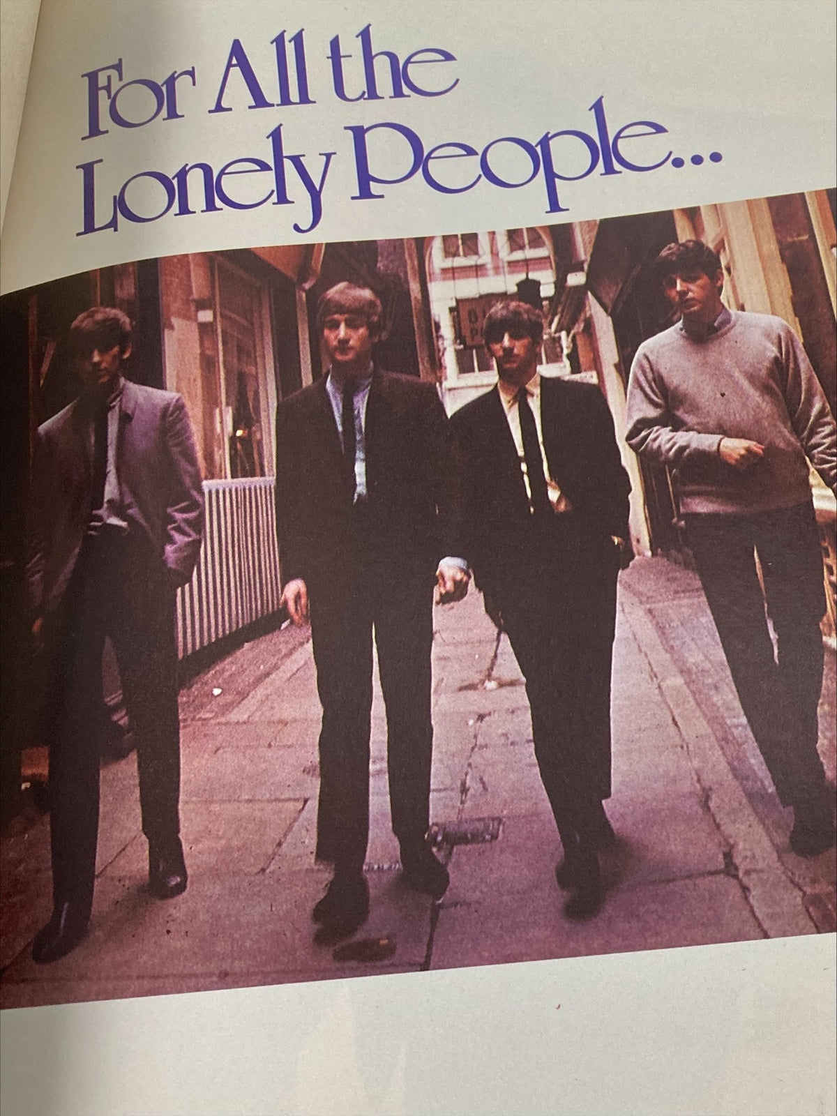 Vintage color photograph of The Beatles walking down a city street with the text 'For All the Lonely People...' prominently displayed, from the 1981 The Beatles' John Lennon Yoko Ono A Memorial Album.