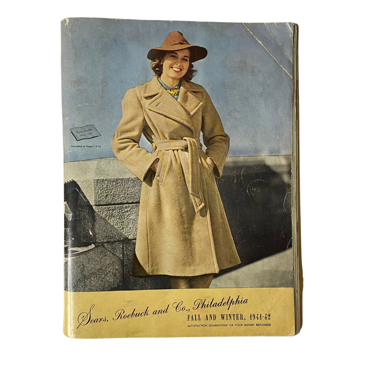 1941 - 1942 Sears Fall and Winter Catalog cover featuring a smiling woman in a stylish beige coat and hat against a blue backdrop.