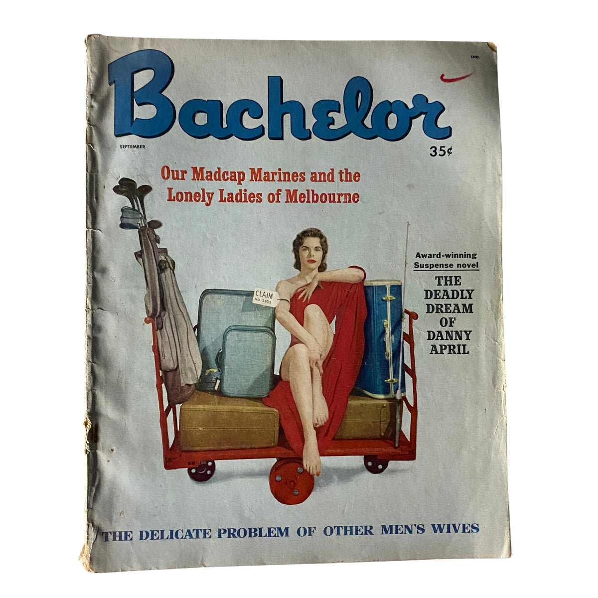 Cover of Bachelor Magazine from September 1958 featuring the title 'The Deadly Dream of Danny April'. The cover illustrates a woman sitting on a luggage cart, dressed in a red outfit, surrounded by suitcases. It highlights articles about 'Our Madcap Marines and the Lonely Ladies of Melbourne'.