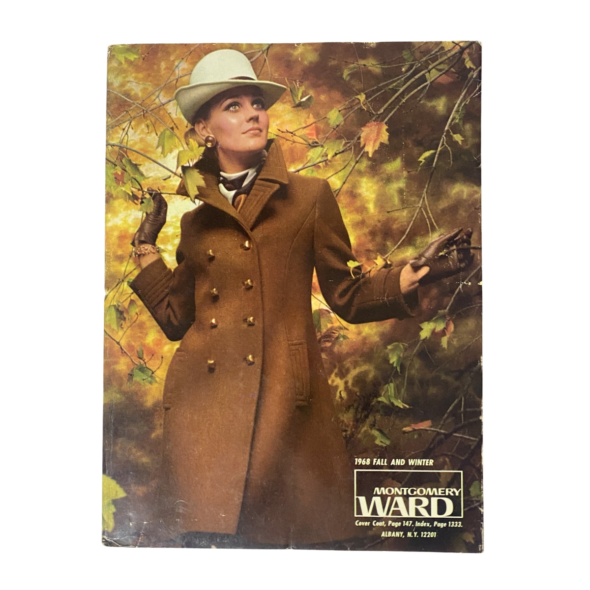 Cover of the 1968 Montgomery Ward Fall and Winter Catalog featuring a woman in a stylish brown coat and white hat against a backdrop of autumn leaves.