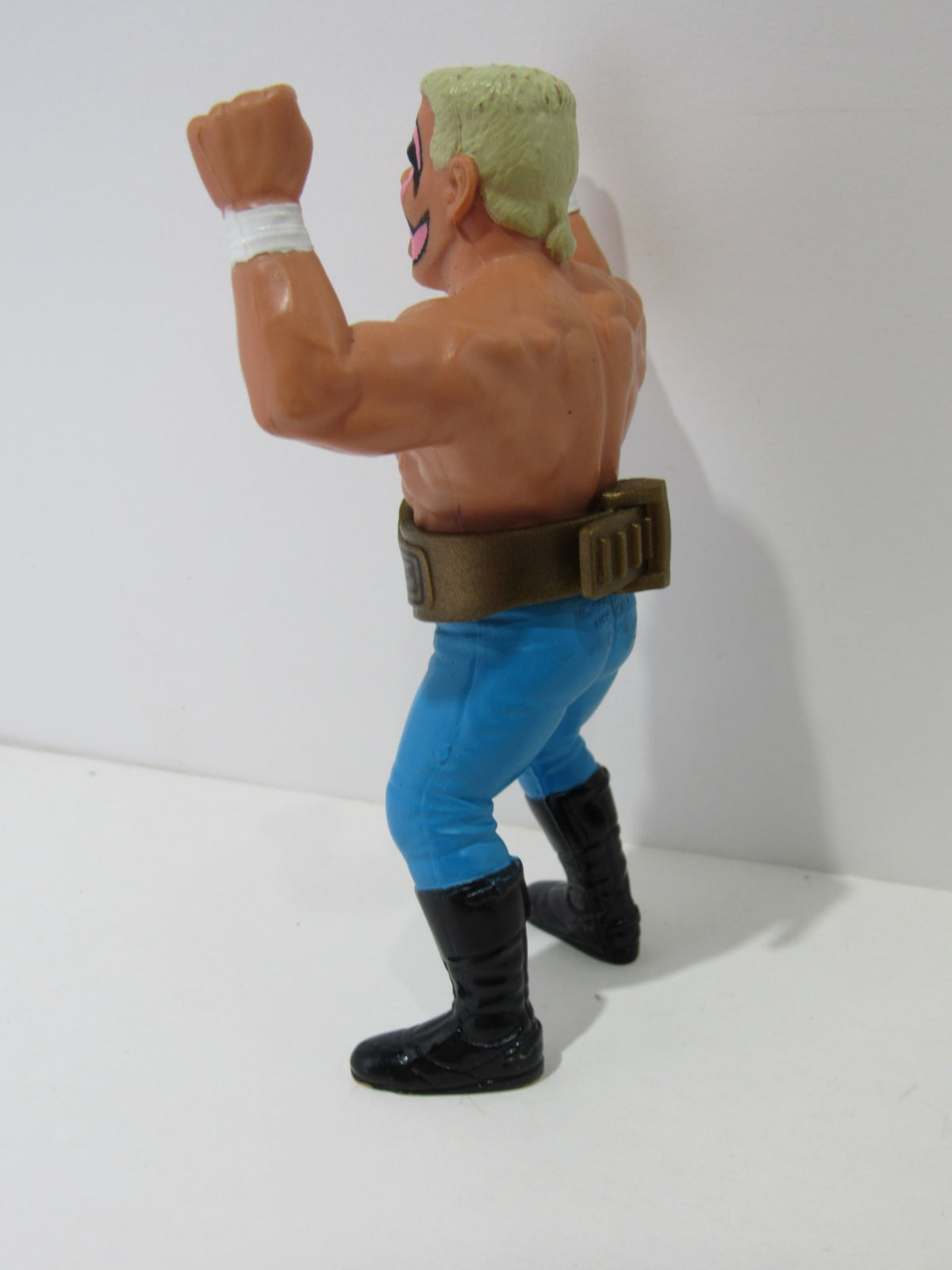 Side view of the 1990 WCW Galoob Sting with Belt Action Figure, highlighted with muscular arms and blue pants.