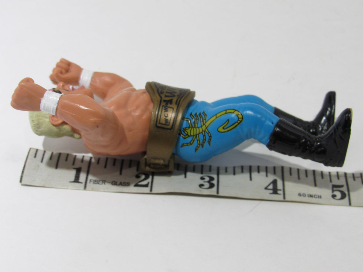1990 WCW Galoob Sting with Belt Action Figure lying on a measuring tape, showcasing its clean and excellent condition.
