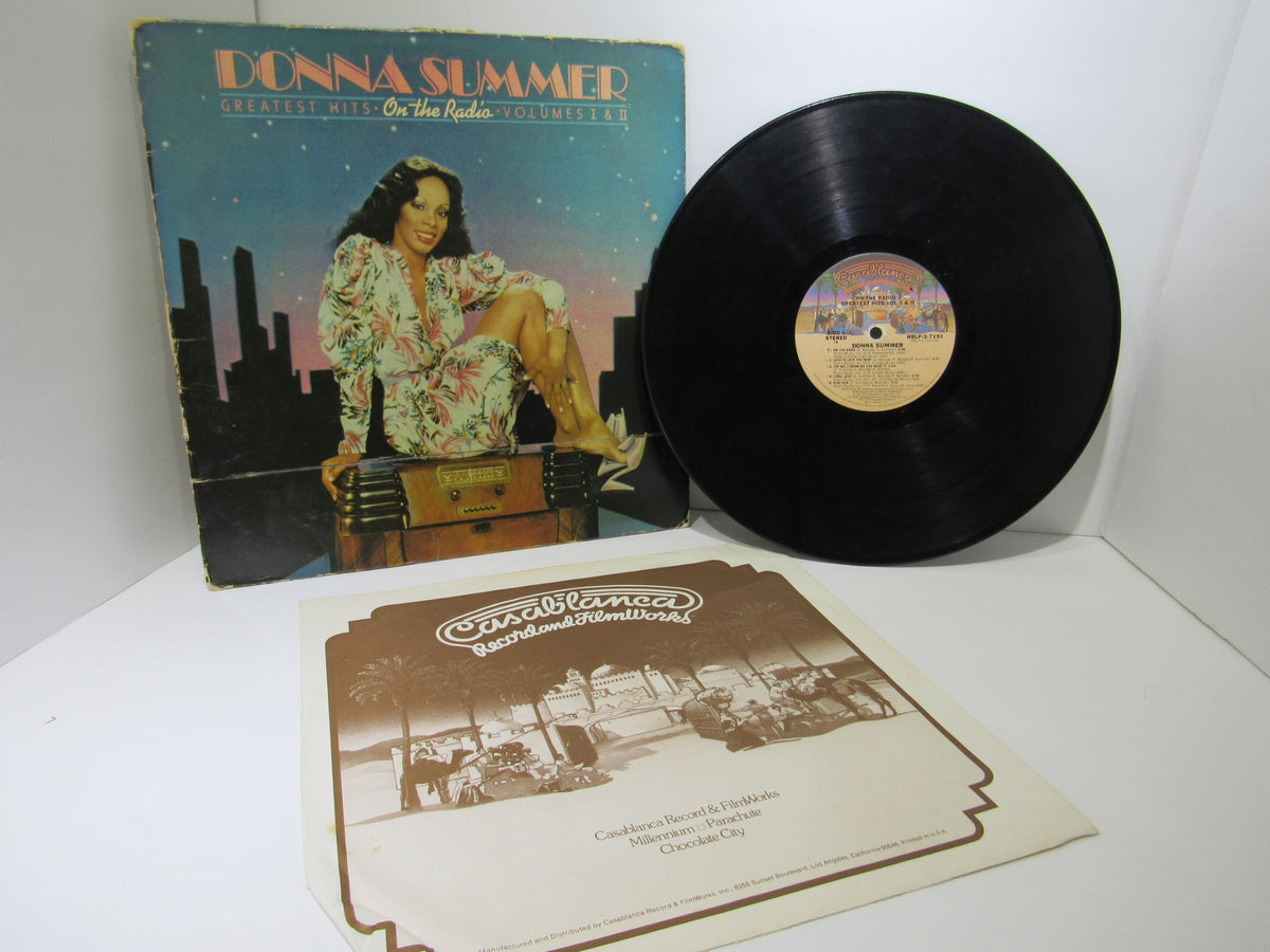 Donna Summer: Greatest Hits on the Radio LP NBLP 27191 featuring the album cover with vibrant colors and retro design, accompanied by the vinyl record on display.