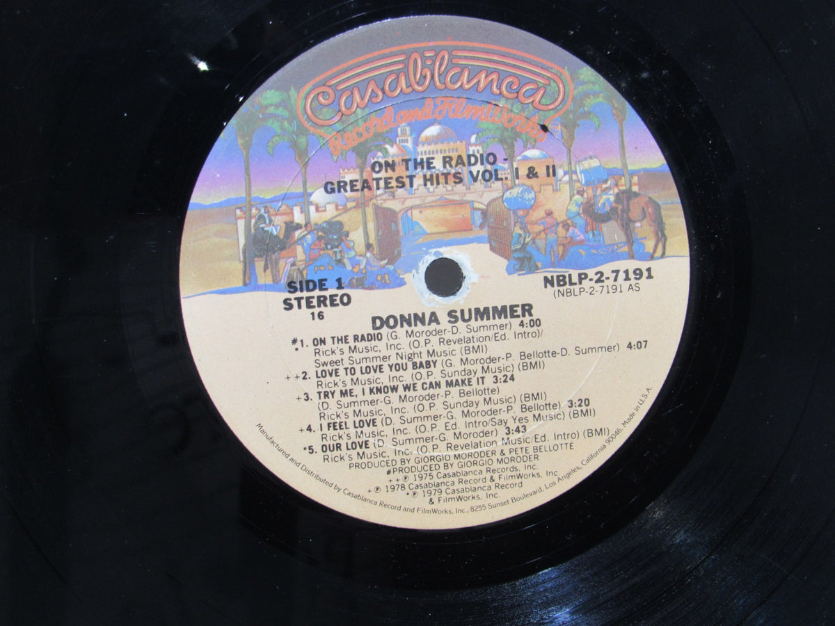 Close-up of the vinyl label of 'Donna Summer: Greatest Hits on the Radio LP NBLP 27191' showing track listings and details.