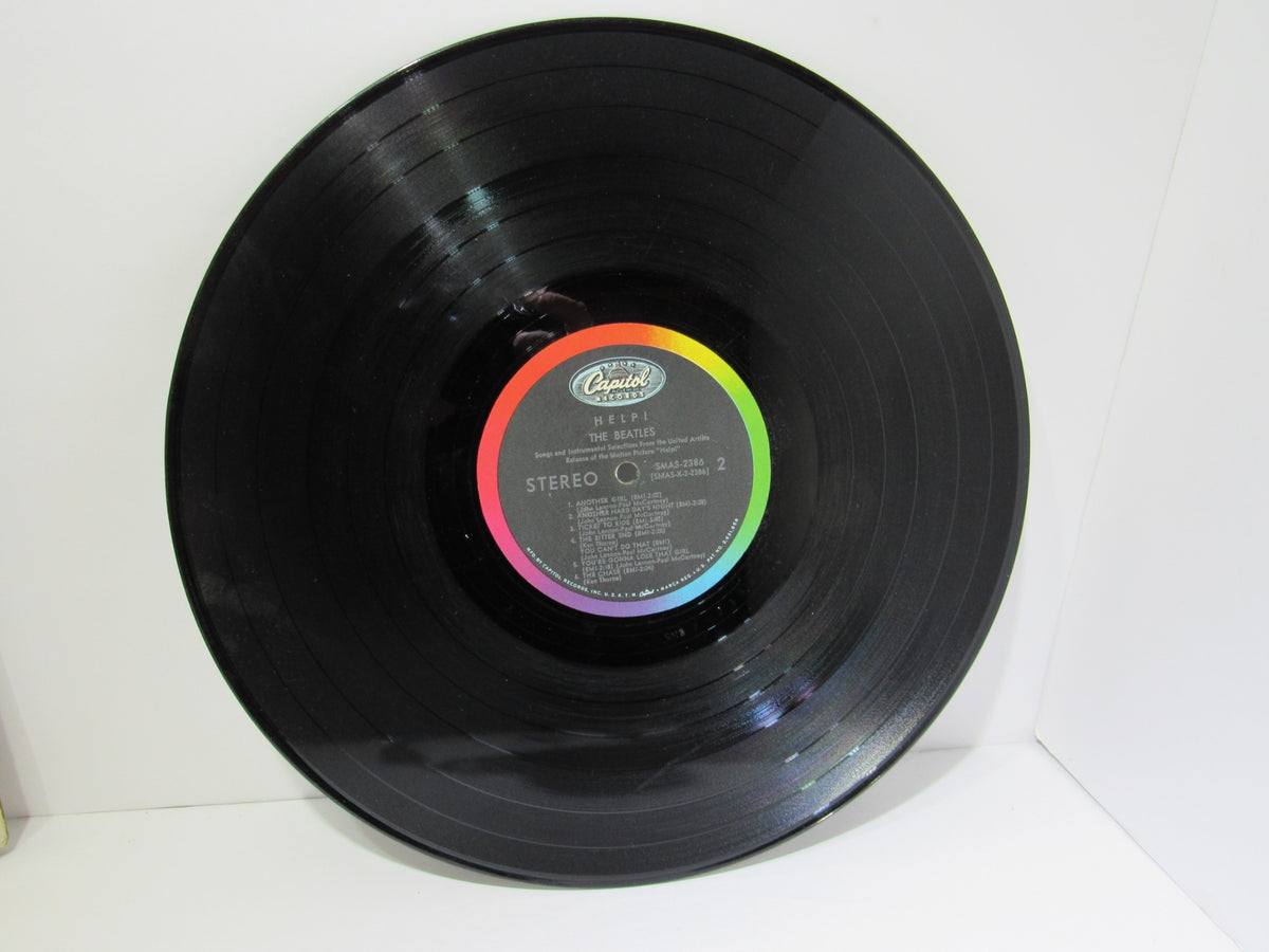 Close-up of the vinyl record for The Beatles Help! OMPS/OST Capitol Gatefold Stereo LP SMAS 2386 highlighting the label and track list.