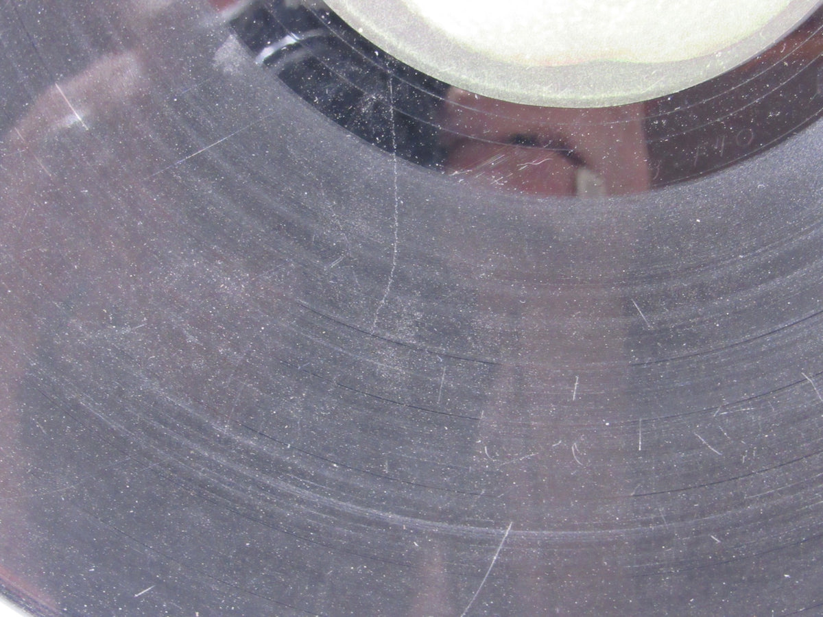 Close-up of the surface of The Beatles: Abbey Road US Press Apple Records LP SO 383 vinyl, highlighting visible scratches.
