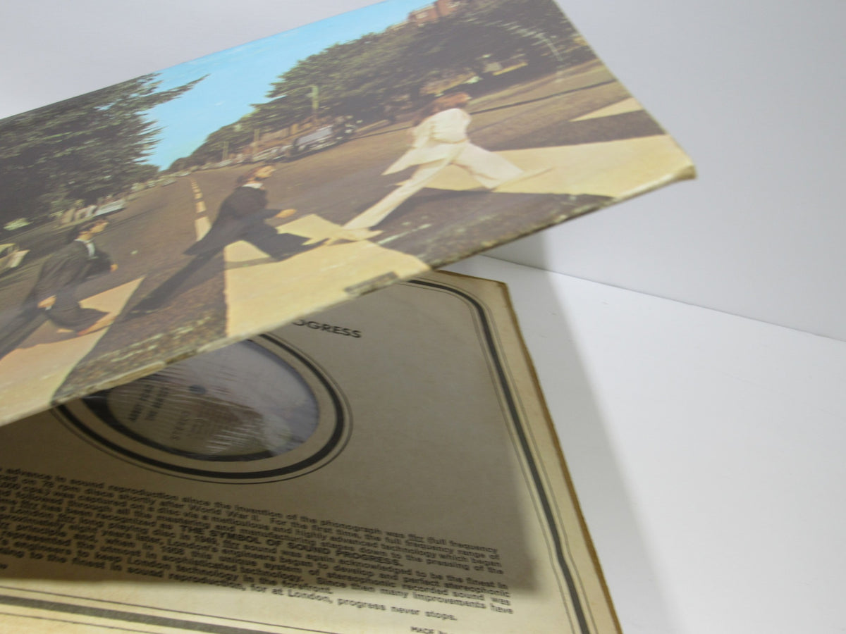 The Beatles: Abbey Road album cover partially opened, showcasing the iconic cover artwork and the inner sleeve.