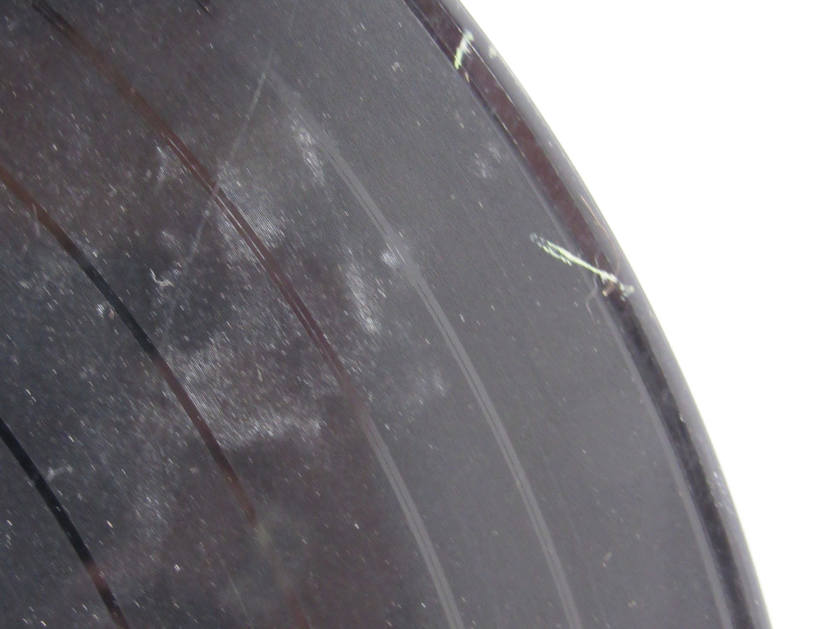 Another close-up of The Beatles: Meet The Beatles US Mono Capitol Records LP T 2047 vinyl, showing noticeable scratches and dust on the record surface.