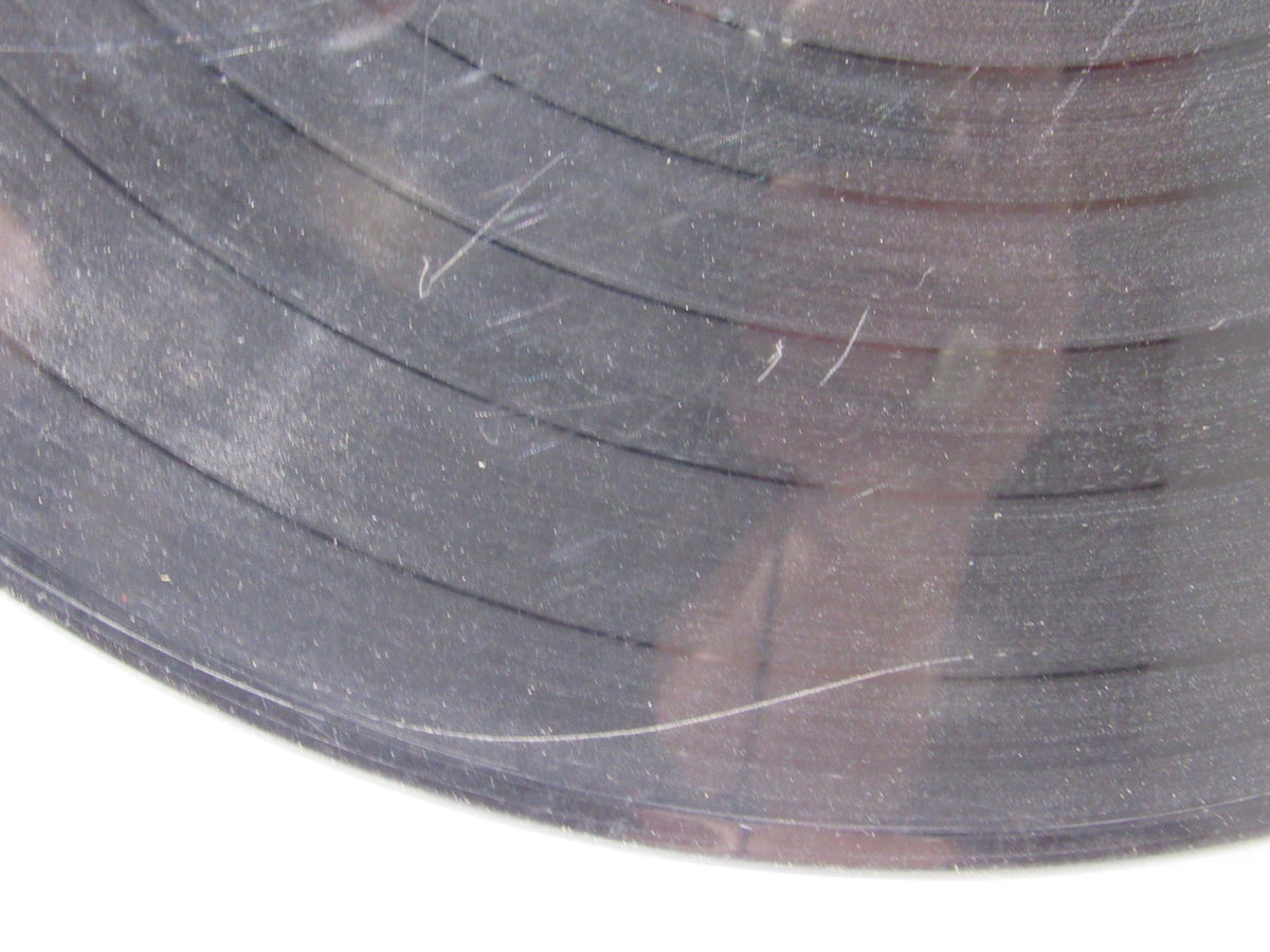 Detailed view of a vinyl record showcasing scratches and dust, part of The Beatles: Meet The Beatles US Mono Capitol Records LP T 2047 Grade: G.