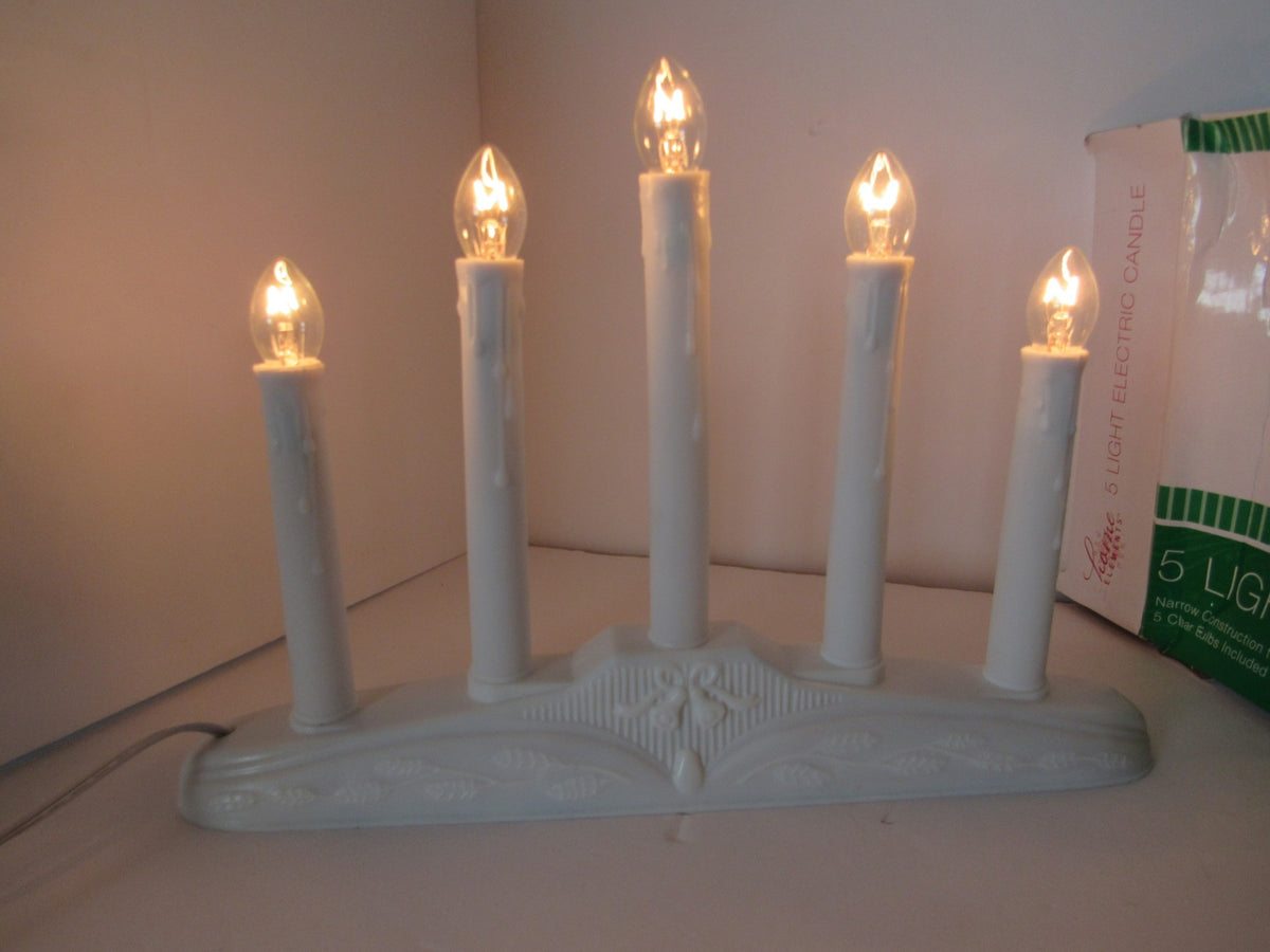 Home Elements Beacon 5 Light Electric Window Candolier Drip Candle Style featuring five lit candle replicas on a decorative white base, ideal for creating a warm, inviting atmosphere.