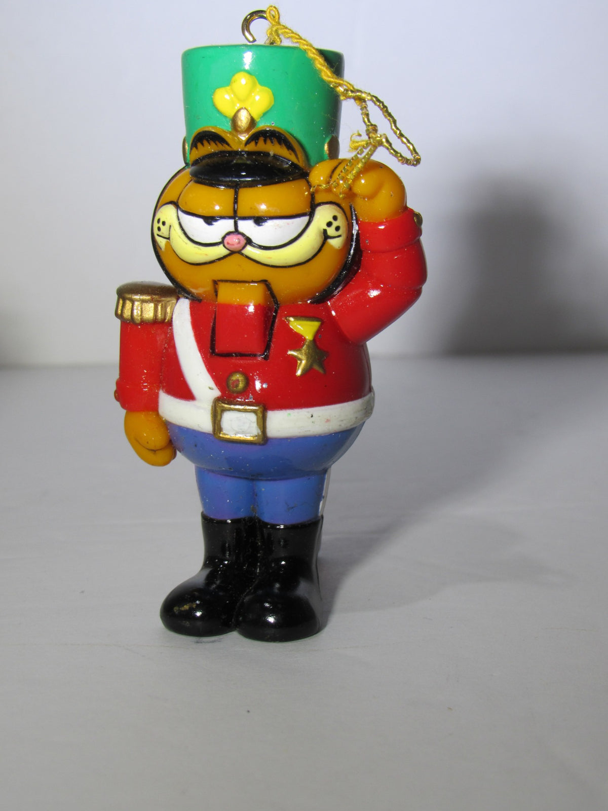 1978 VTG Enesco Treasury of Christmas Ornament featuring Garfield as The Nutcracker, depicted in a colorful uniform, standing tall with a green hat and saluting pose.