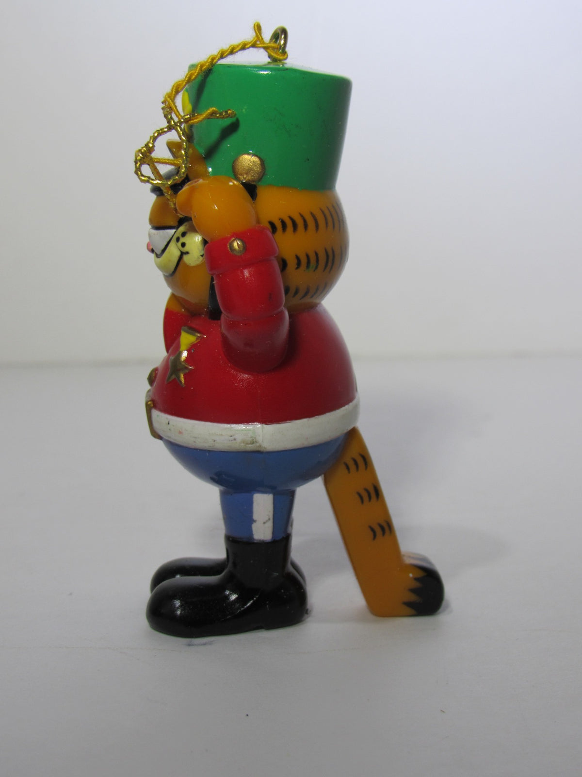 Side view of the 1978 VTG Enesco Treasury of Christmas Ornament featuring Garfield as The Nutcracker, showcasing his vibrant outfit and iconic salute.