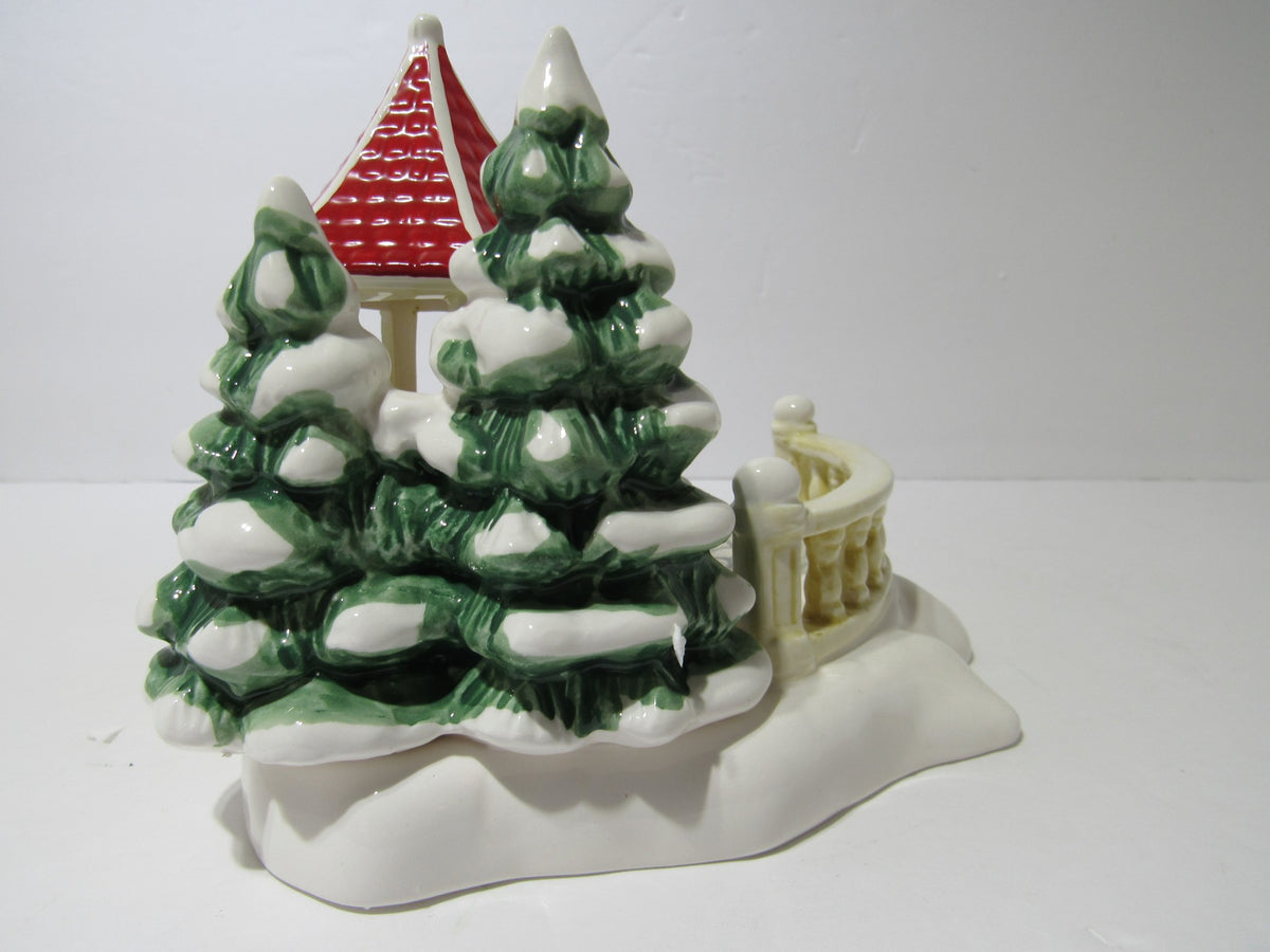 Back view of 1989 Vintage Department 56 Snow Village Series Village Gazebo showcasing the snow-laden trees and architecture.