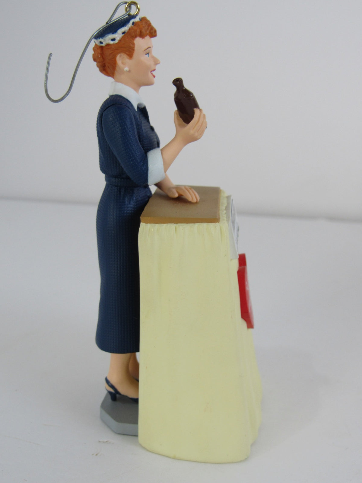 Side view of a 2001 Hallmark Keepsake Ornament depicting I Love Lucy's VitaMeataVegamin character holding a product, illustrating vibrant colors.