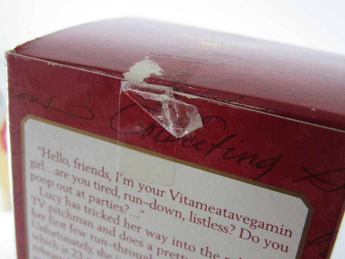Close-up of the damaged box of 2001 Hallmark Keepsake Ornament I Love Lucy VitaMeataVegamin, showing wear and tear from storage.