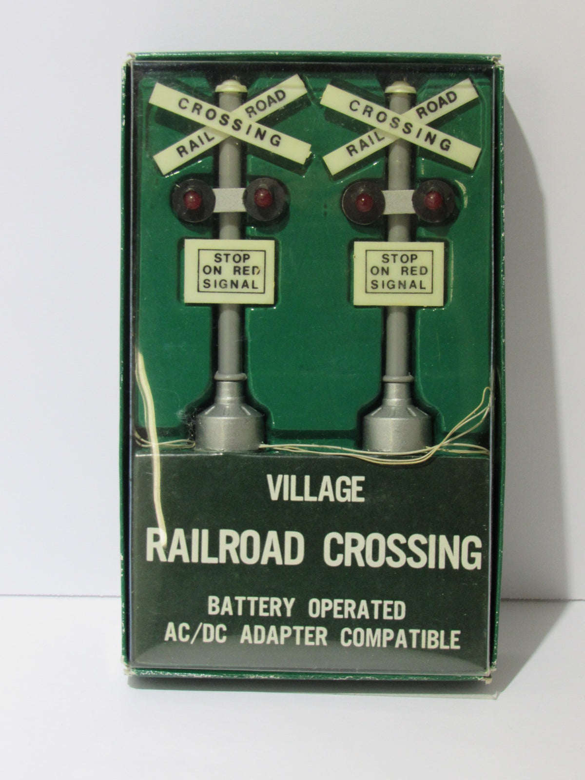 Department 56 Village Railroad Crossing Signal #5501-8 in original packaging, showcasing a vintage battery-operated decorative piece with railroad crossing signs and lights.
