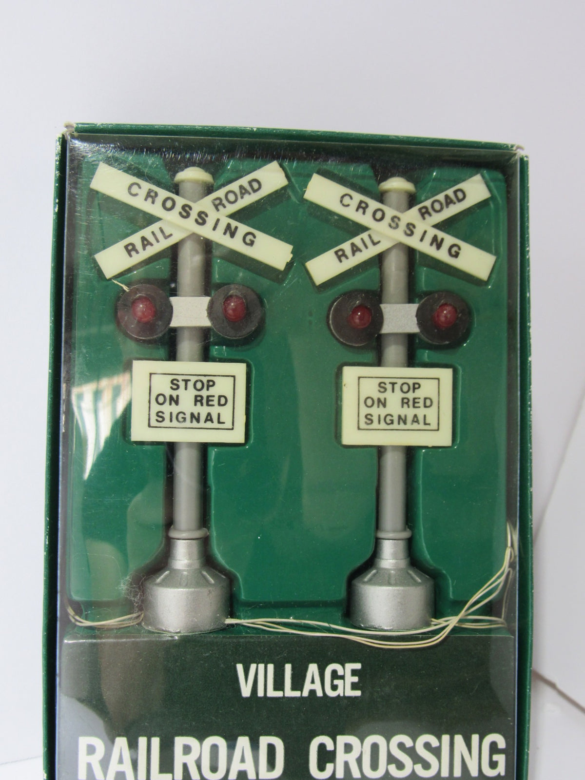 Close-up view of Department 56 Village Railroad Crossing Signal #5501-8, highlighting the detailed design of the decorative piece with stop signs and red lights.