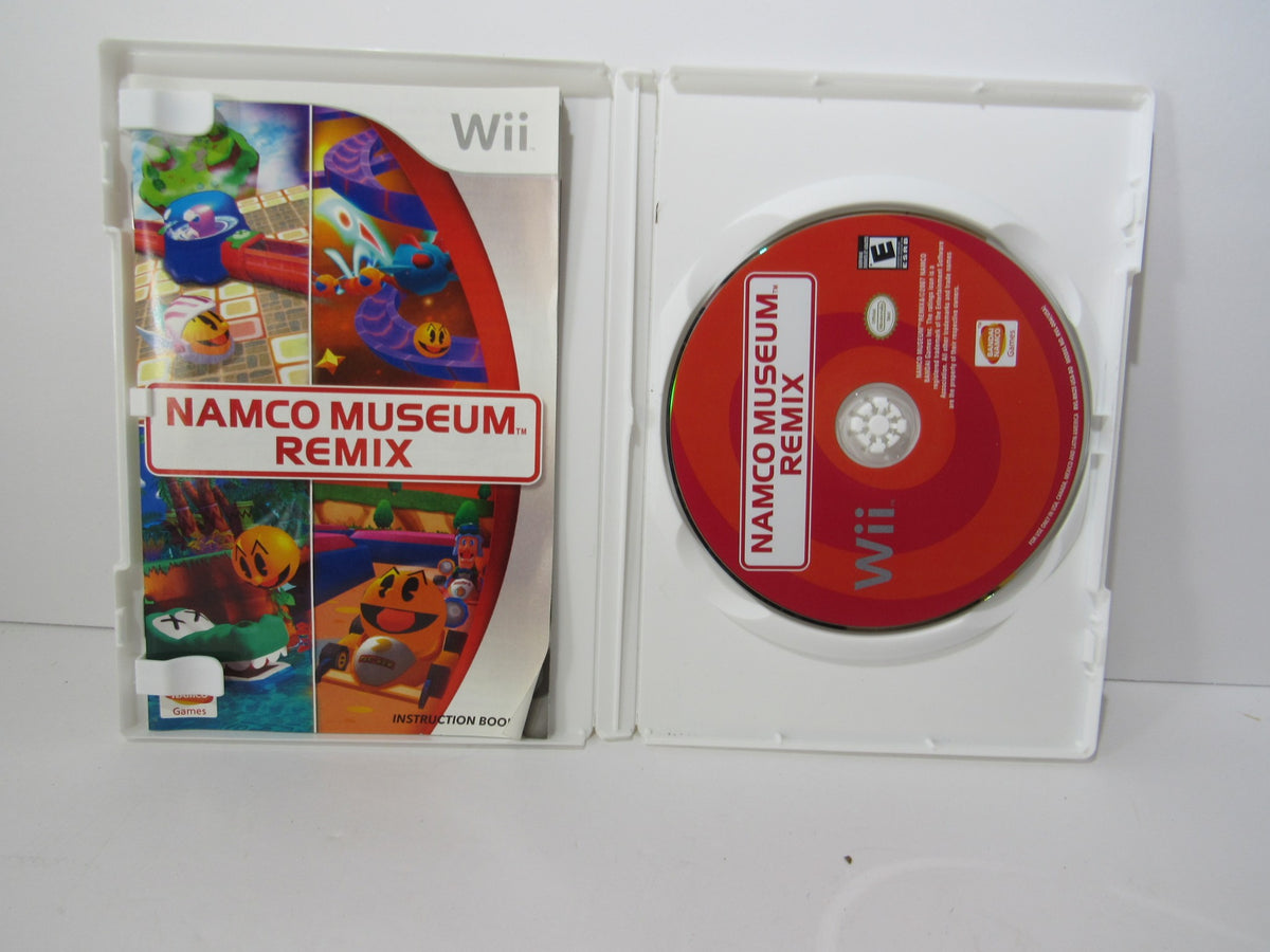 2007 Namco Museum Remix Nintendo Wii game case opened, showcasing the game disc and colorful cover featuring various characters.