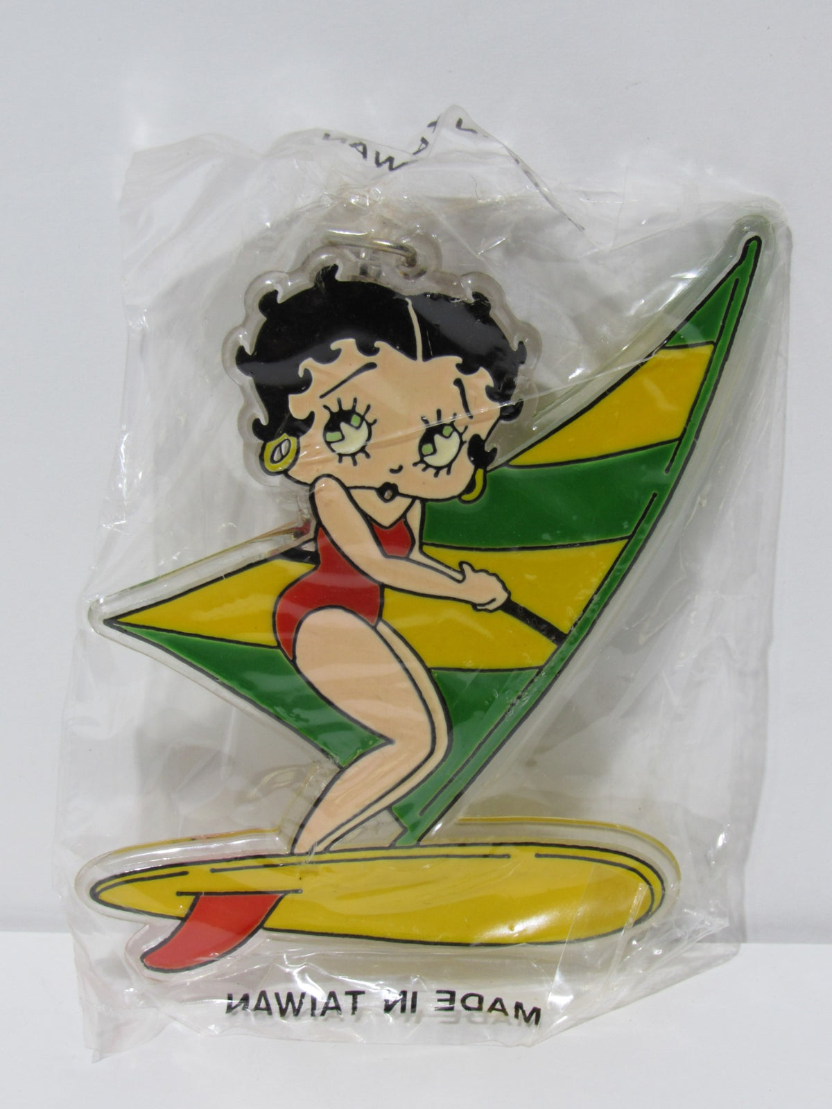 1985 Rare Vintage Surfing Betty Boop Key Chain featuring Betty Boop in a red swimsuit on a surfboard with a multicolored sail, brand new condition.