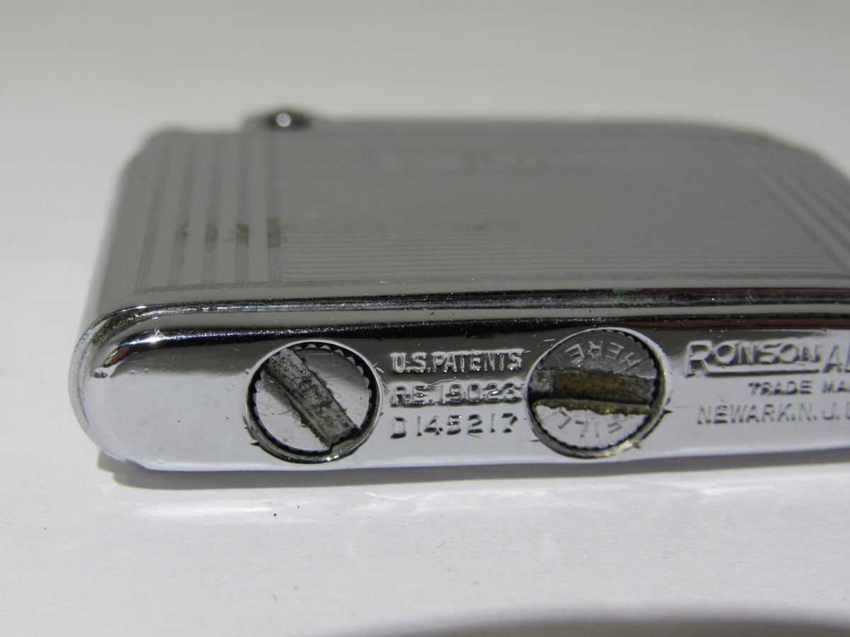 Another view of the underside of Vintage Ronson Adonis Chrome Striped Lighter #145217 highlighting the patent details.