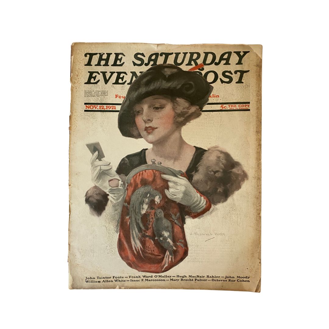Cover of The Saturday Evening Post, November 12, 1921, featuring a fashionable woman with a hat and elegant attire, holding a mirror, highlighting the vintage style and cultural trends of the early 20th century.