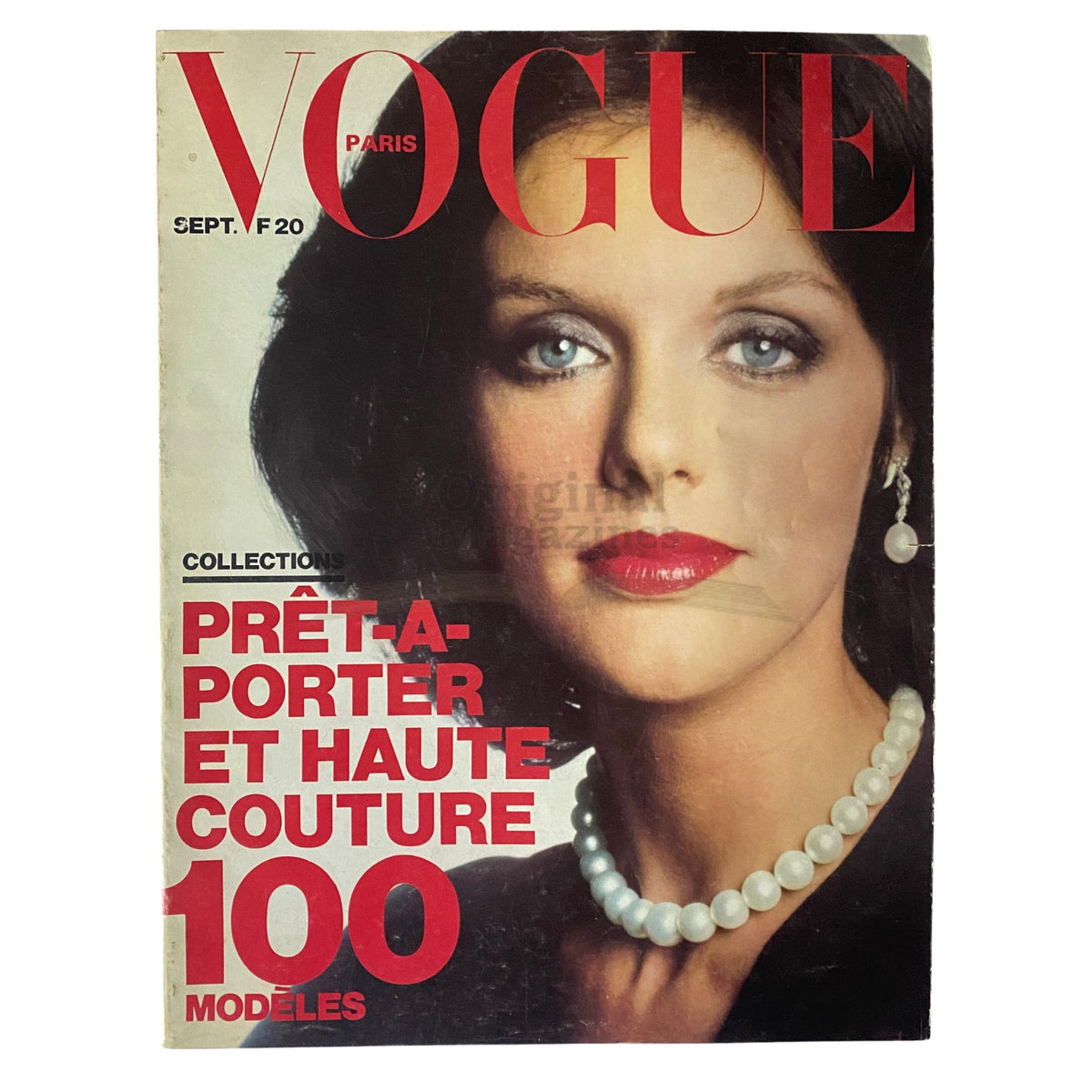 Vogue Paris Magazine September 1973 cover featuring a portrait of a woman with dark hair and striking blue eyes, wearing a pearl necklace and bold makeup. This vintage magazine highlights collections of prêt-à-porter and haute couture fashion trends from the era.