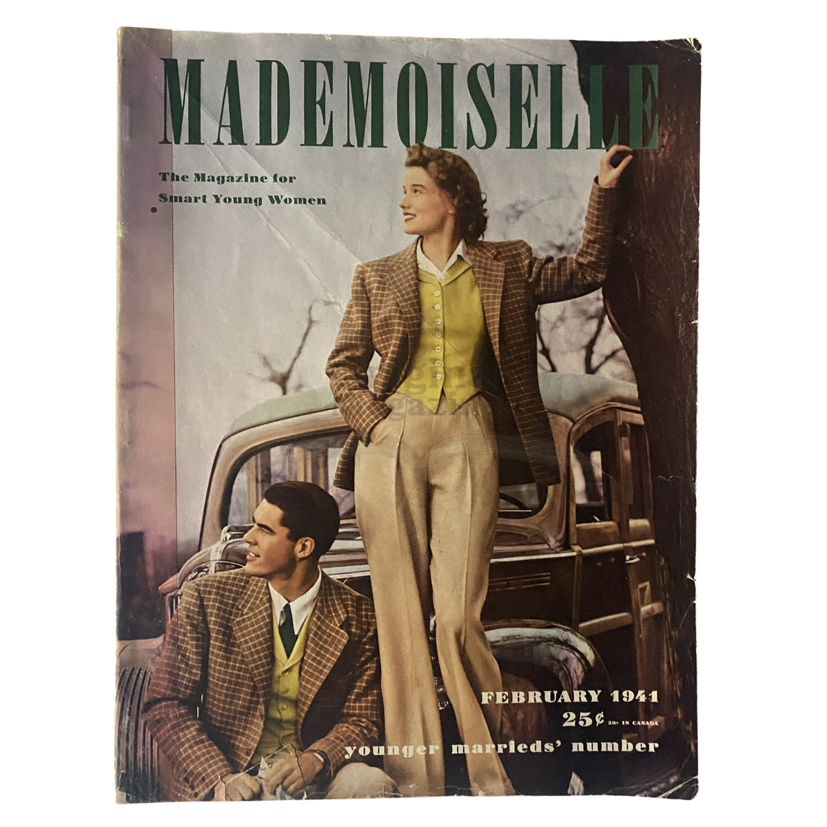 Cover of Mademoiselle Magazine February 1941 Younger Marrieds' Number, featuring a woman in a stylish plaid blazer and yellow vest standing beside a man in a coordinated outfit, set against a vintage car backdrop, reflecting early 1940s fashion trends.