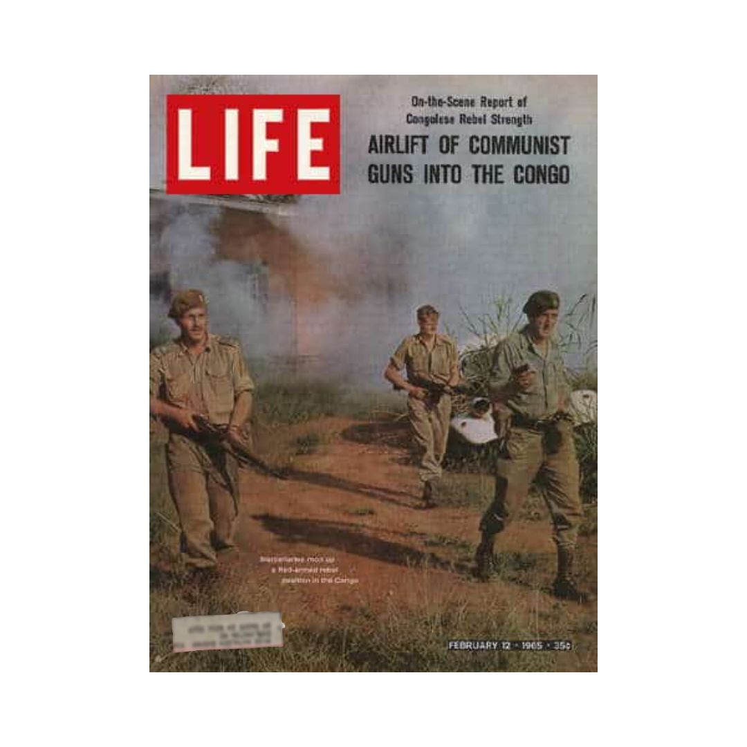 Cover of VTG Life Magazine February 12, 1965, featuring the article 'Airlift of Communist Guns into the Congo'. The image shows soldiers with guns in a smoke-filled battlefield, highlighting significant historical moments during the Cold War.