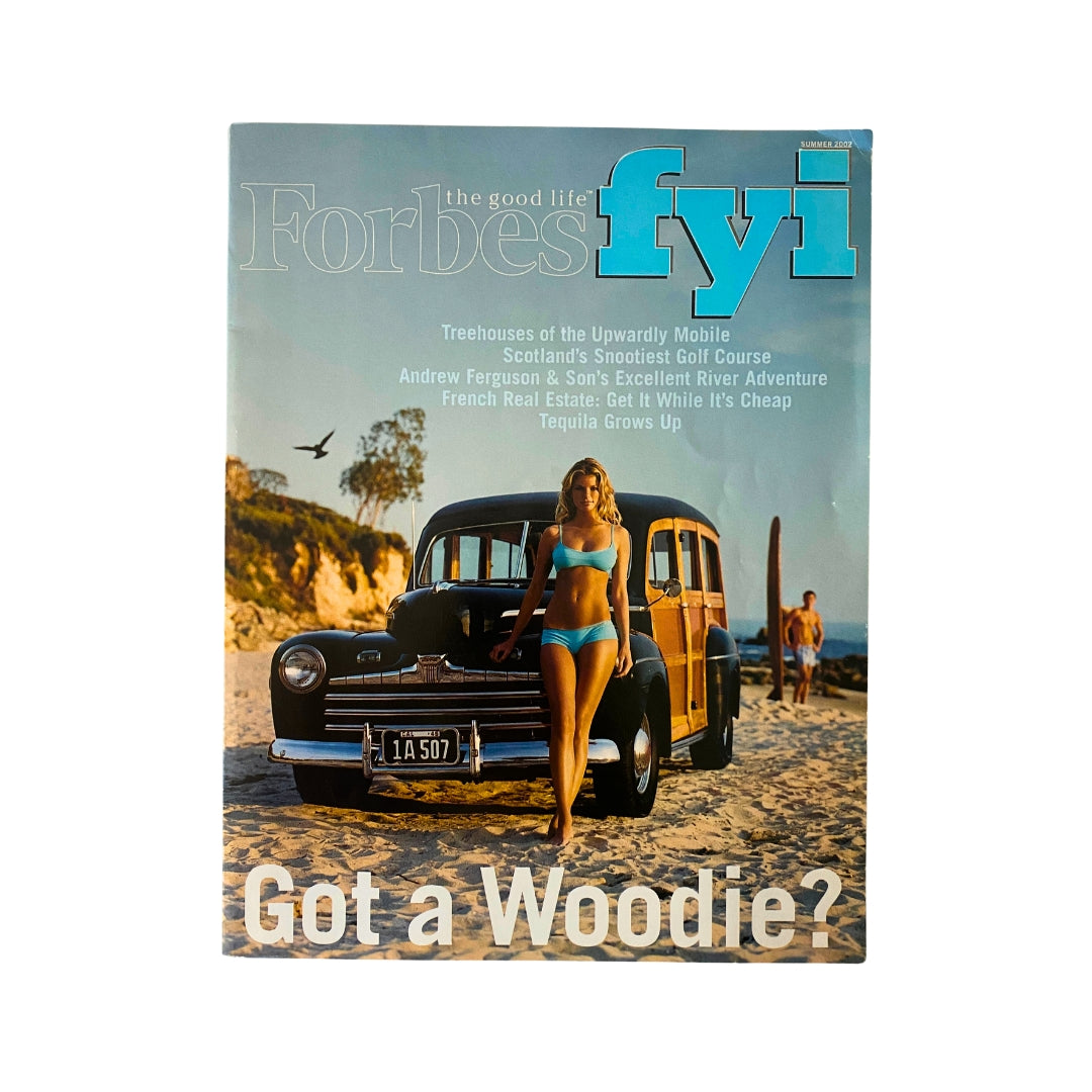 The Good Life Forbes FYI Magazine Summer 2002, titled "Upwardly Mobile," featuring a vintage scene with a woman in a bikini by a classic woodie car on a beach, capturing early 2000s lifestyle and nostalgia.